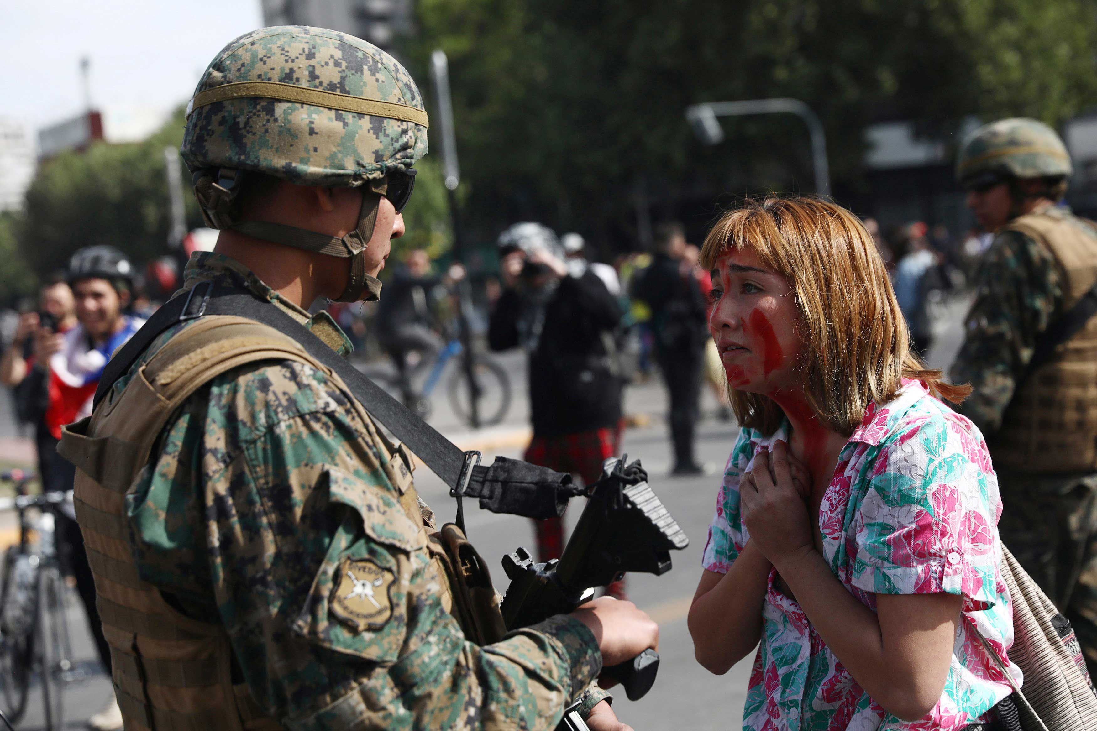 Una manifestante hablando con un militar en Santiago de Chile (REUTERS)