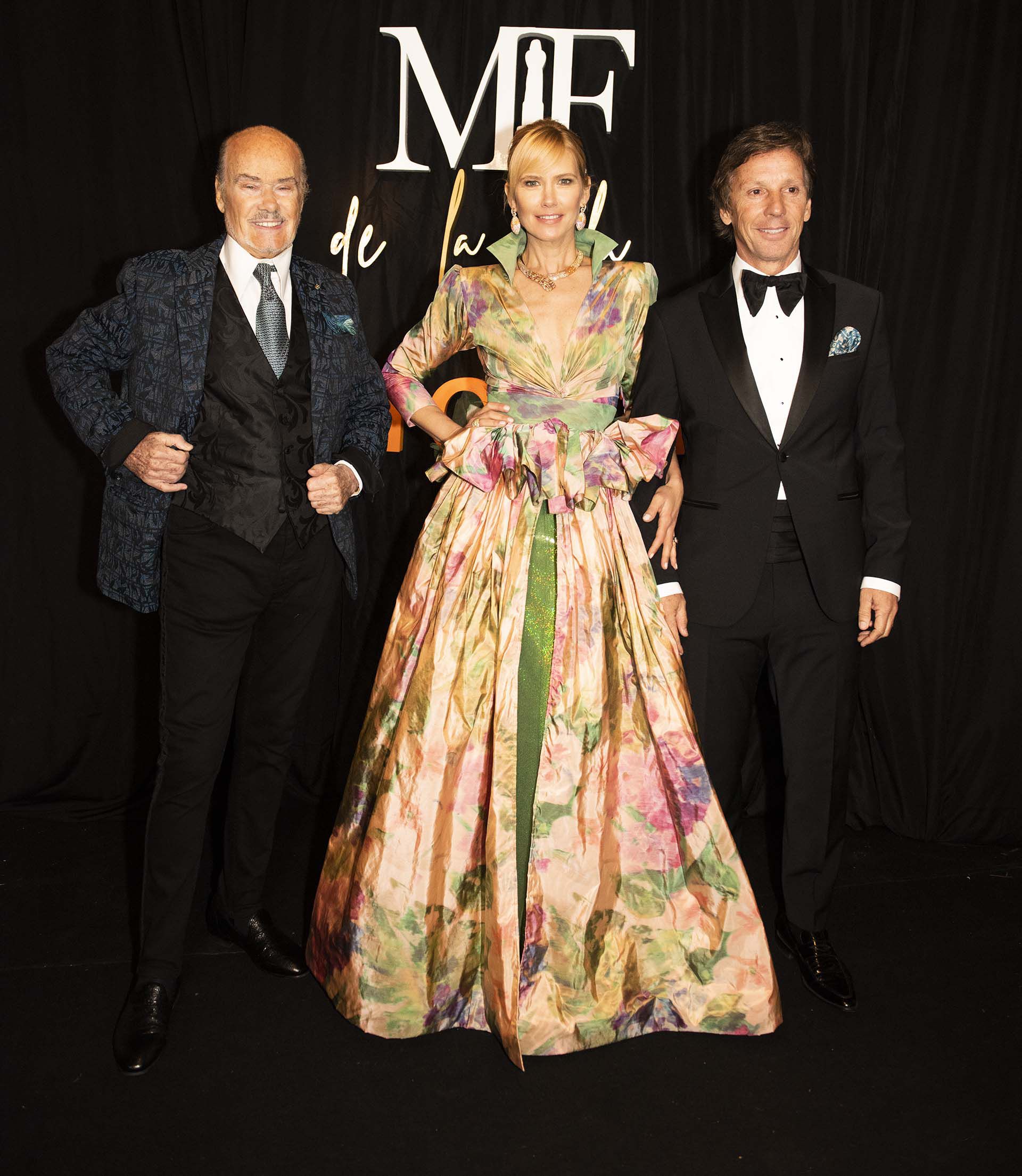 Valeria Mazza con un vestido multicolor, corte en la cintura y cuello del diseñador Gino Bogani, junto con el diseñador de su vestido Gino Bogani y su marido Alejandro Gravier 