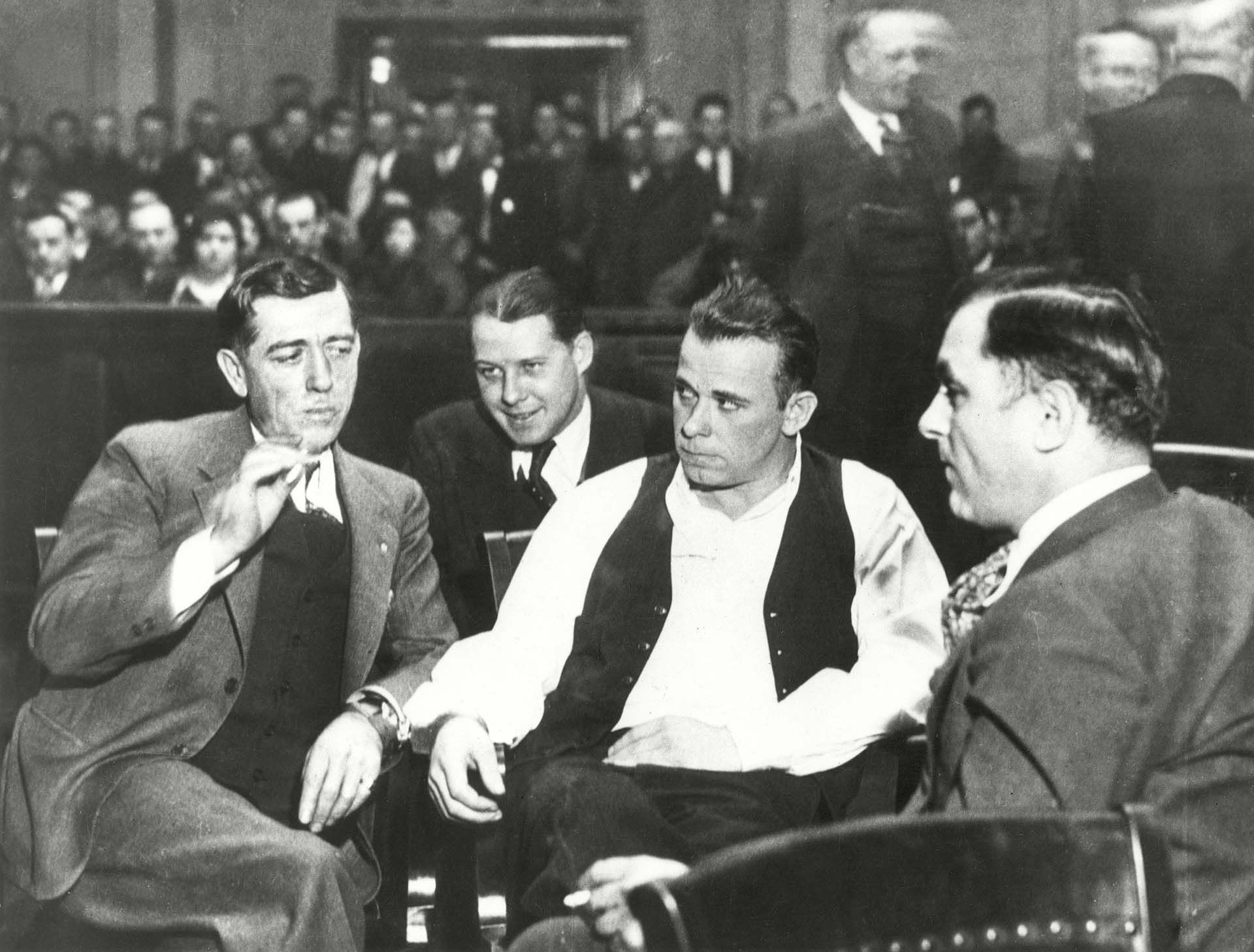 John Dillinger (con chaleco abierto) rodeado de guardias en su orden de arresto en la corte en Crown Point, Indiana, el 9 de febrero de 1934, bajo el cargo de matar a un policía en el este de Chicago (Shutterstock)