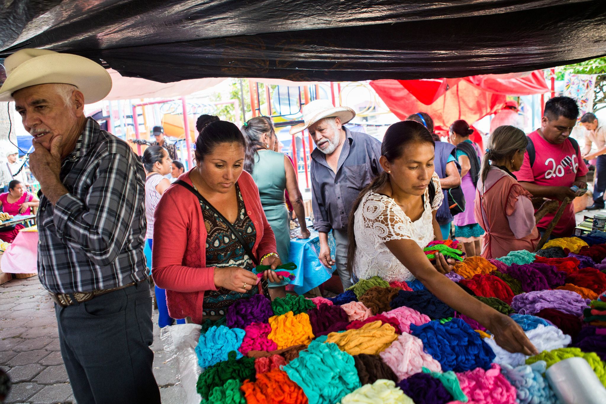Unas mujeres compran el hilo de colores brillantes utilizado en el tipo de bordado hecho en los pueblos alrededor de Tenango de Doria, en el estado mexicano de Hidalgo.Credit...Celia Talbot Tobin para The New York Times