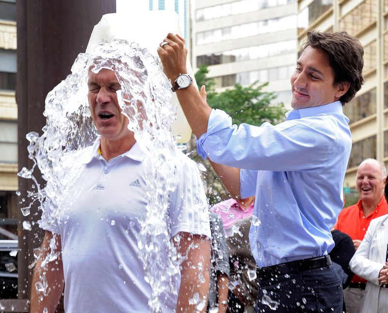 Foto de archivo: El líder liberal Justin Trudeau arroja un cubo de agua helada sobre el parlamentario Sean Casey en el desafío del cubo de hielo de ALS en Edmonton, en Canadá. 19 de agosto de 2014. REUTERS/Dan Riedlhube