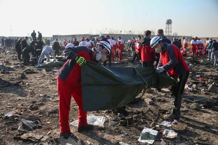  Miembros de la Media Luna Roja revisan bolsas de plástico en el sitio donde el avión de Ukraine International Airlines se estrelló tras ser abatido por un misil antiaéreo (Reuters)