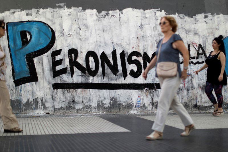 Foto de archivo. Una mujer camina frente a un grafiti en Buenos Aires. 11 de diciembre 2019. REUTERS/Ueslei Marcelino
