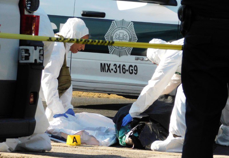 Técnicos forenses inspeccionan un cuerpo dejado en medio de la calle, en la delegación Venustiano Carranza de Ciudad de México, México. 14 de enero de 2020. REUTERS/Stringer