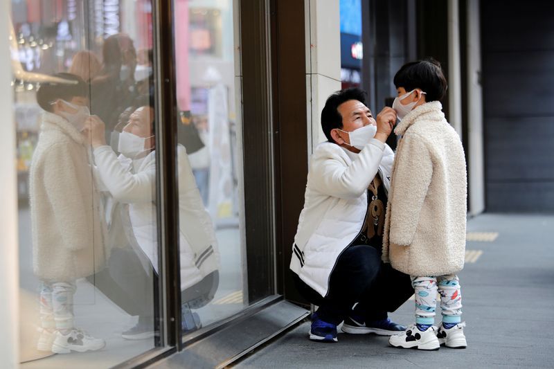 Un hombre y un niño usan mascarillas para evitar contraer un nuevo coronavirus, en el distrito comercial de Myeongdong, en Seúl, Corea del Sur. 20 de febrero de 2020. REUTERS/Heo Ran.