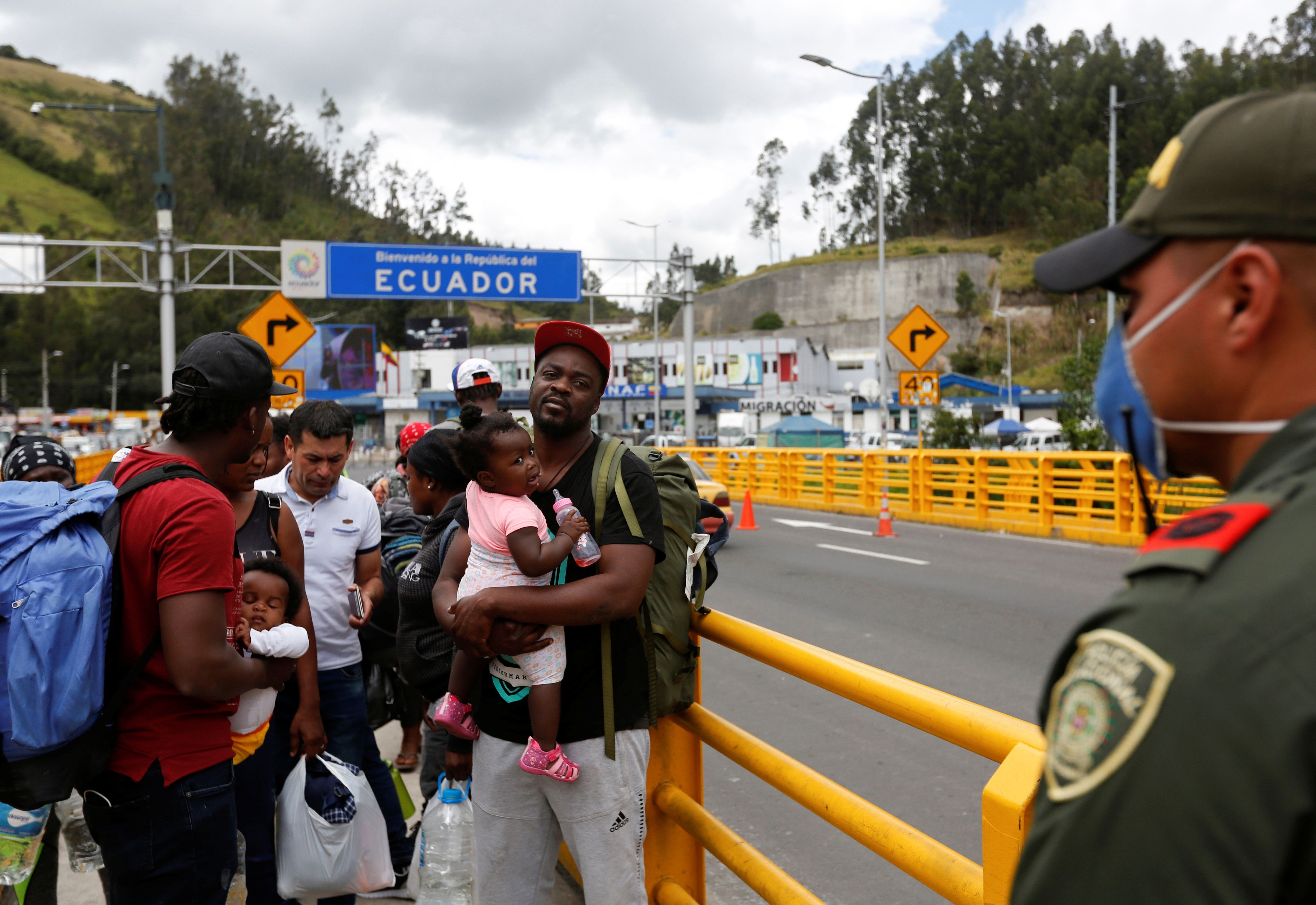 Un grupo de haitianos cruza la frontera entre Colombia y Ecuador después de que el gobierno de Ecuador anunciara el sábado el cierre de estas para evitar la propagación del coronavirus. REUTERS/Daniel Tapia