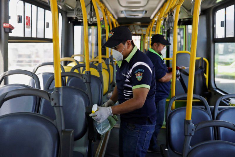 Imagen de archivo. Trabajadores usando mascarillas limpian el interior de un autobús de transporte público, en medio de las preocupaciones por el crecimiento del coronavirus en Ciudad de Guatemala, Guatemala. 15 de marzo de 2020. REUTERS/Luis Echeverria