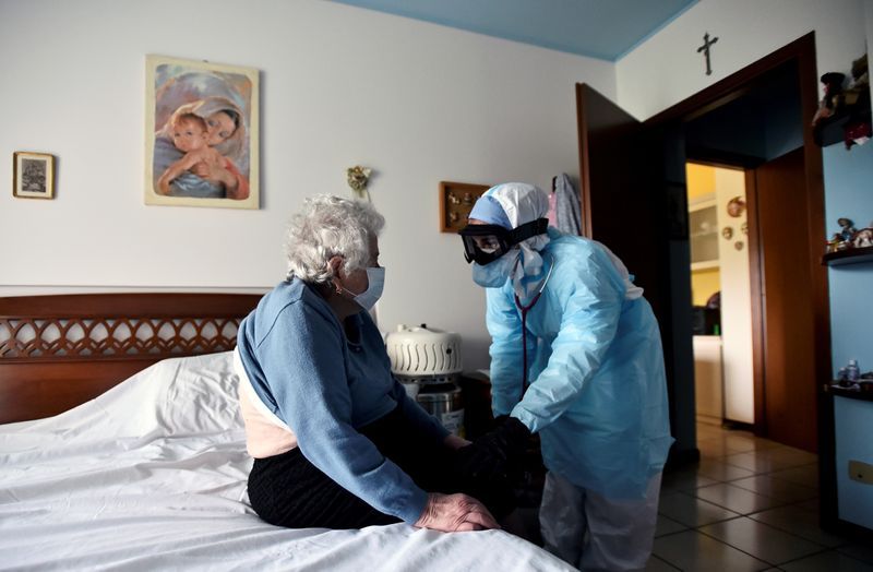 Un doctor con un traje protector visita una persona con COVID-19 en su casa en Bergamo, en el epicentro del brote en Italia, 16 de abril del 2020. (REUTERS/Flavio Lo Scalzo)