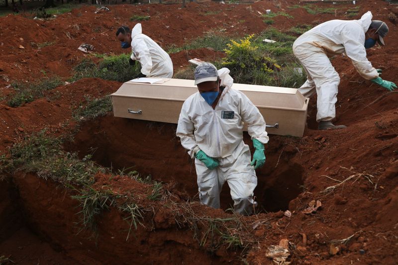 Sepultureros con trajes protectores preparan el entierro de una persona fallecida por coronavirus en el cementerio de Sao Paulo. Mayo 22, 2020. REUTERS/Amanda Perobelli