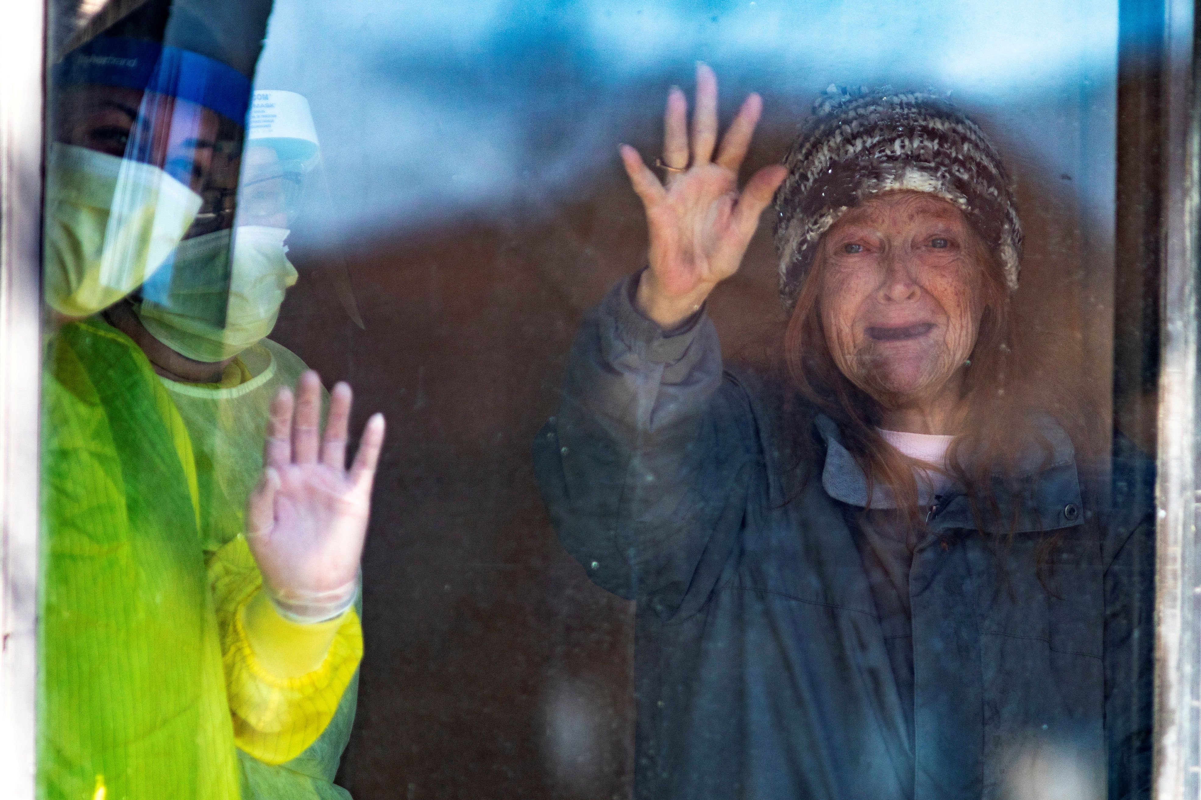 Una residente de un centro para ancianos saluda a los autos que tocan la bocina como señal de apoyo en Canadá (Reuters)