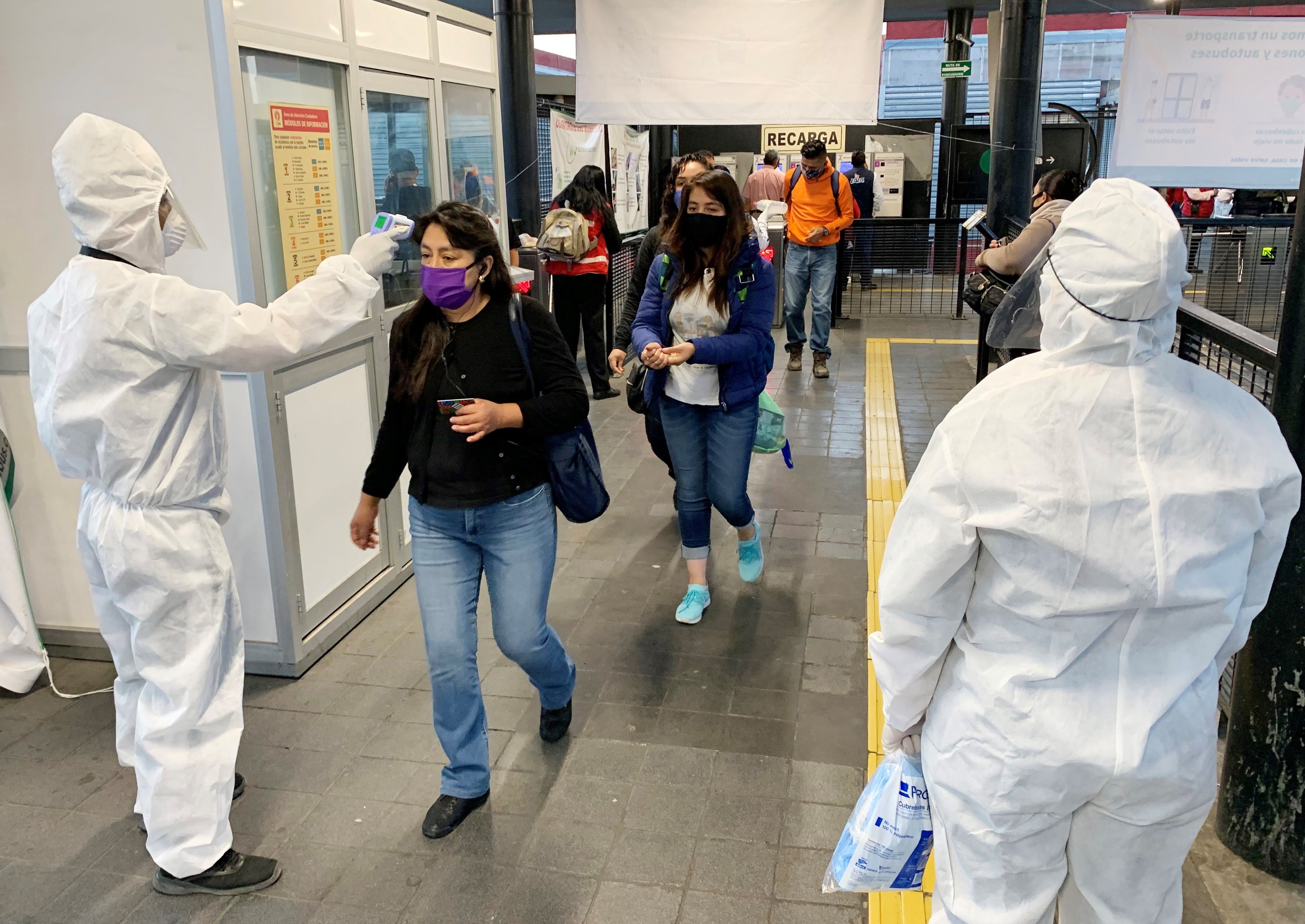 Usuarios del Metrobús pasan un filtro de seguridad y desinfección donde personal de Seguridad Pública, les toma la temperatura y les aplica gel antibacterial para poder ingresar a las instalaciones del sistema de transporte de Ciudad de México. 