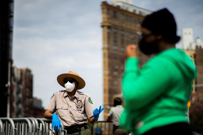 Un guardabosques urbano habla con gente después de quedarse sin máscaras durante una distribución gratuita en la Plaza del Gran Ejército, durante el brote de la enfermedad coronavirus (COVID-19) en el barrio de Brooklyn de la ciudad de Nueva York. 3 de mayo de 2020. REUTERS/Eduardo Muñoz
