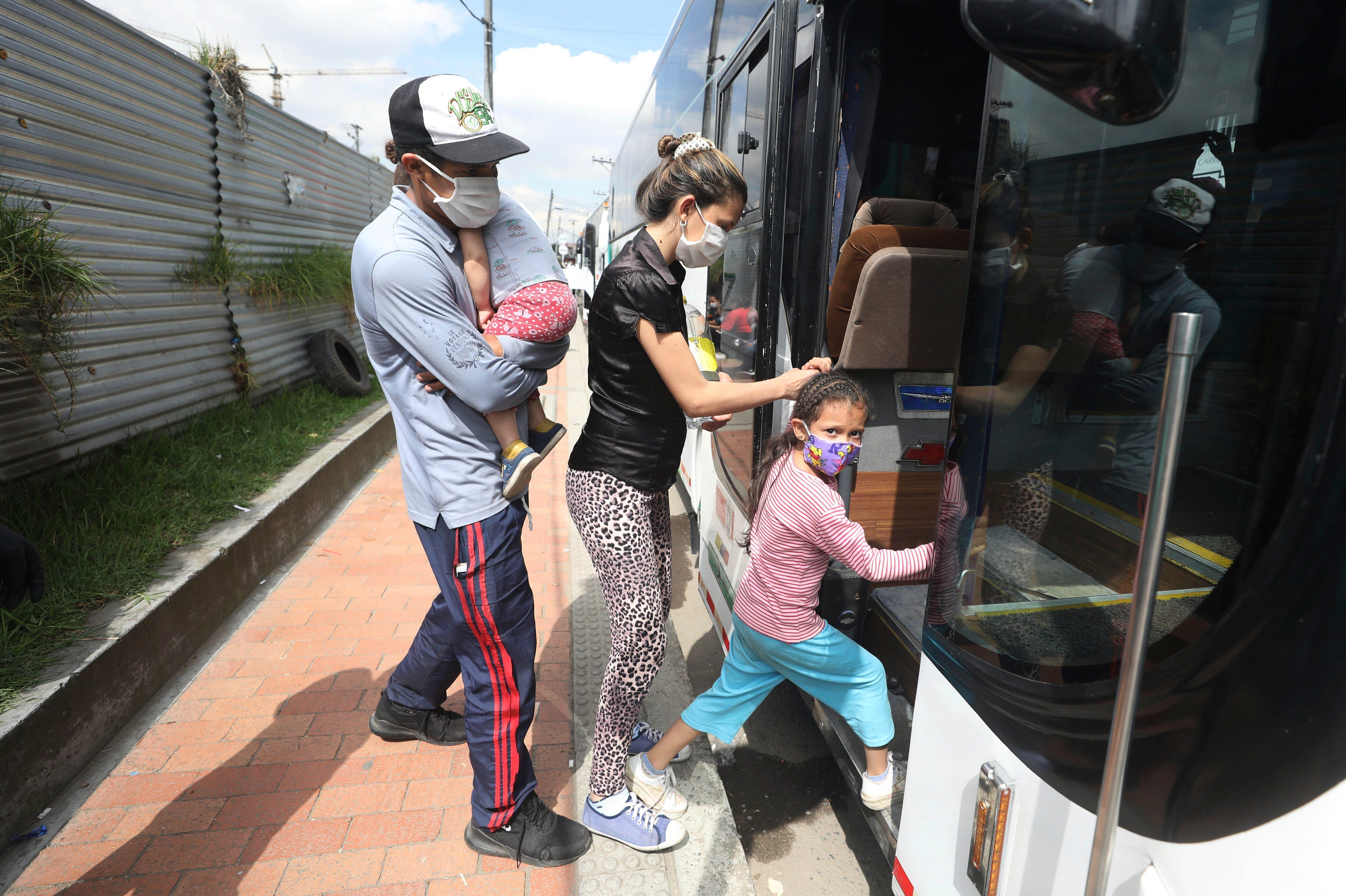 En esta imagen del 30 de abril de 2020, migrantes venezolanos suben a un autobús con destino a la frontera venezolana, en medio de la pandemia del nuevo coronavirus, en Bogotá, Colombia. (AP Foto/Fernando Vergara)