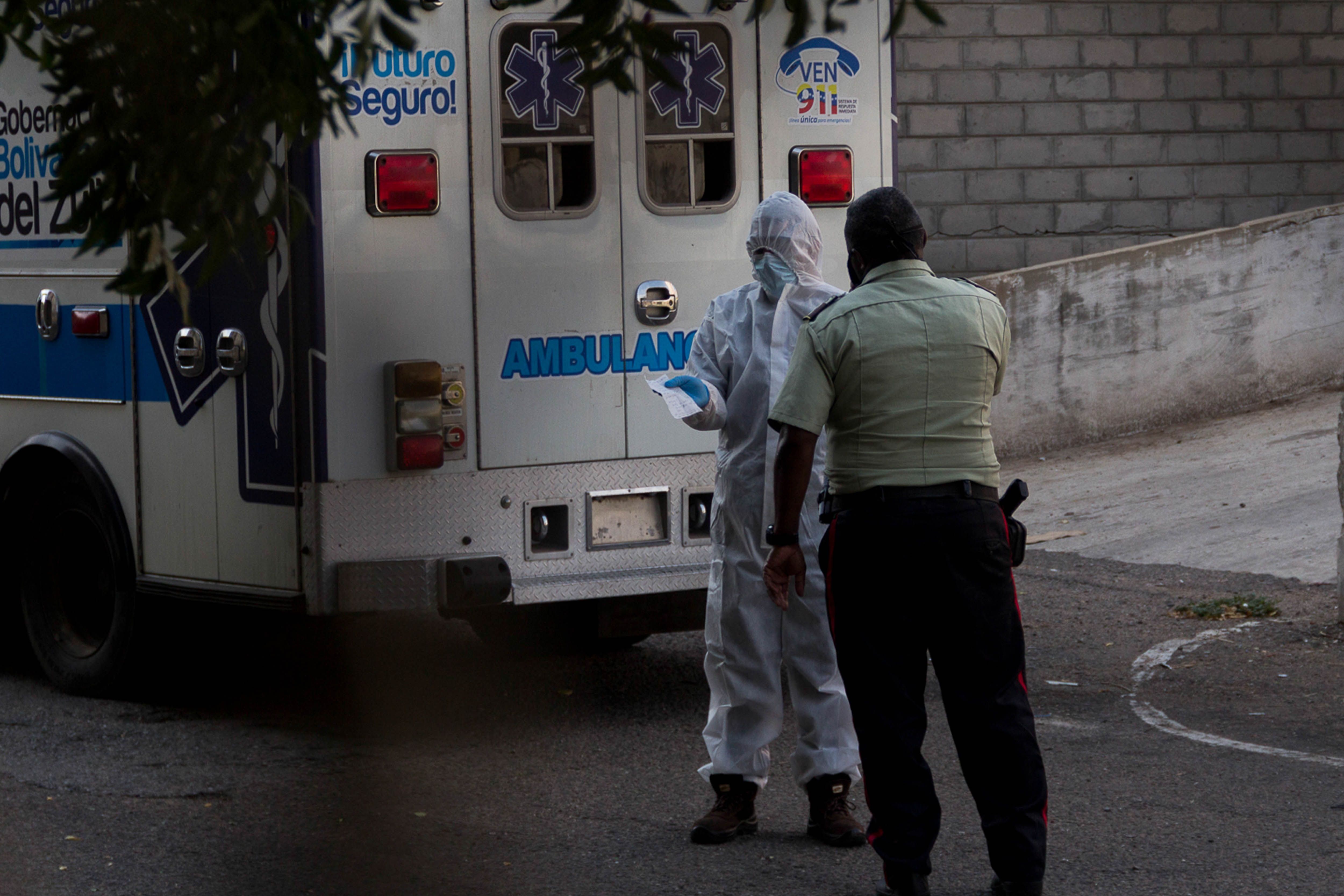 Fotografía del 28 de mayo de 2020 donde se observan miembros de la gobernación del estado Zulia detrás de una ambulancia, momentos antes de buscar a una persona sospechosa de COVID-19, en Maracaibo (Venezuela). EFE/ Henry Chirinos/ Archivo 