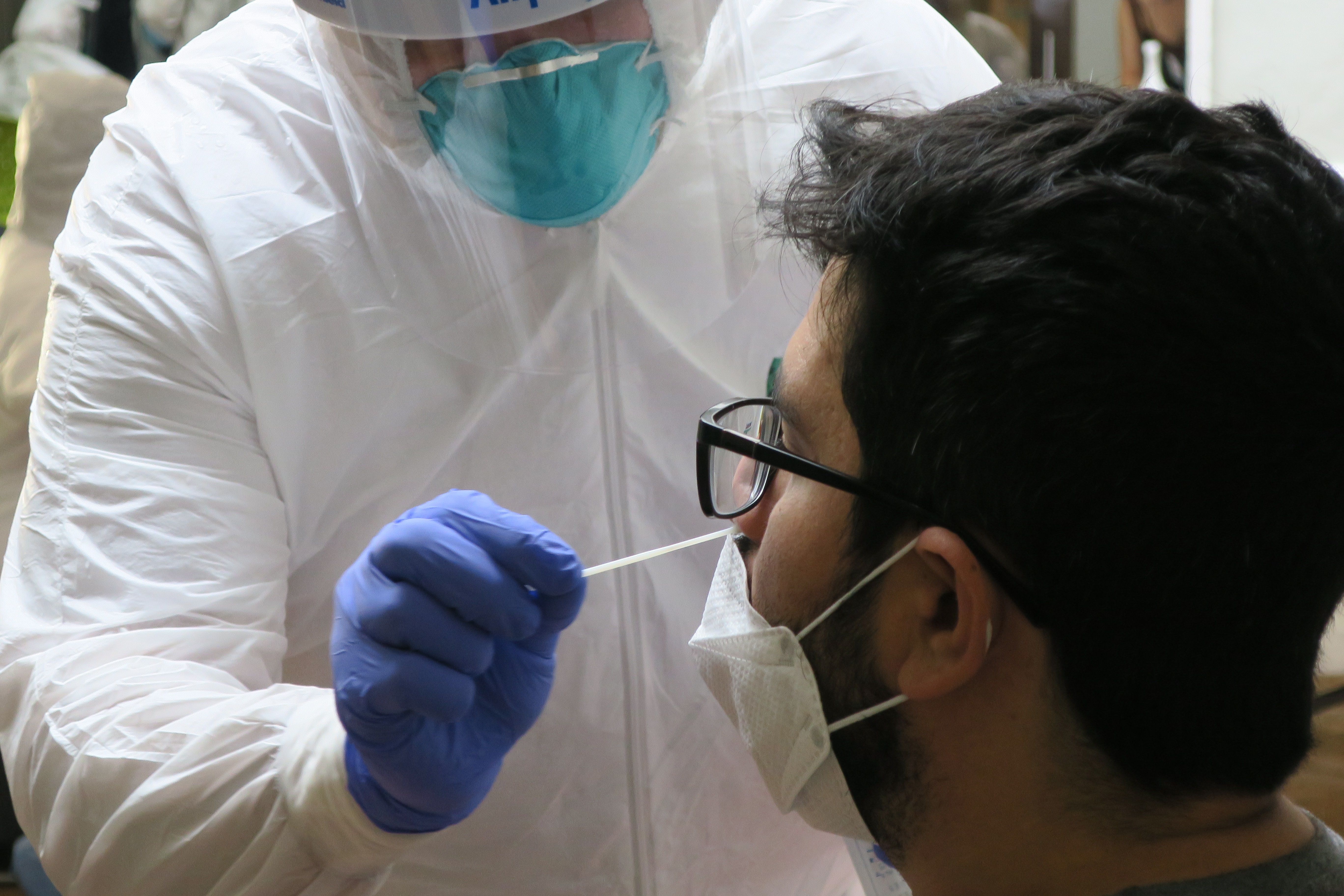 Un técnico de laboratorio inserta un hisopo en la nariz de un joven. EFE/ Jorge Muñiz/Archivo 