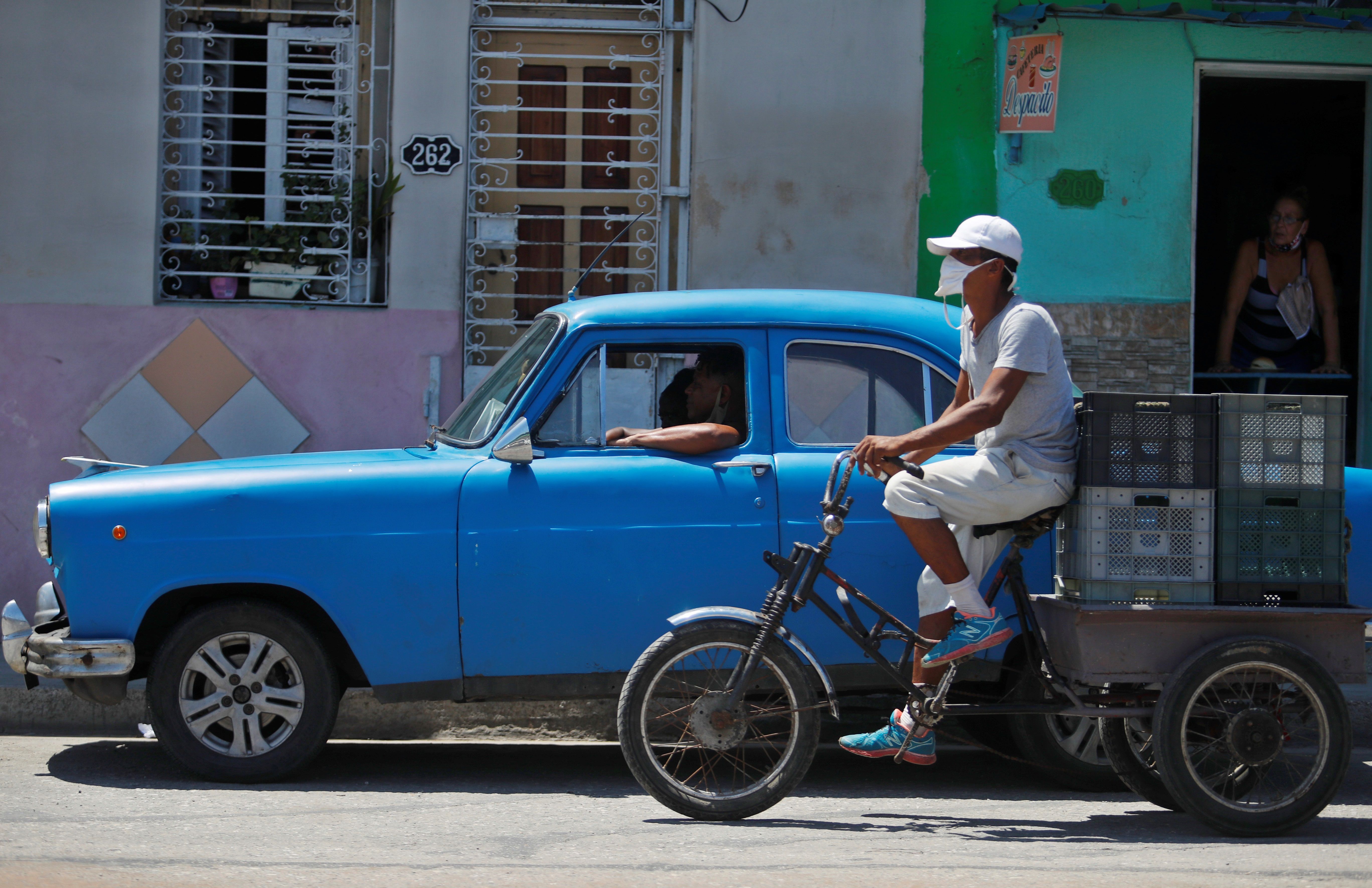 Un hombre en bicicleta y un automóvil clásico transitan por una calle el 1 de septiembre de 2020 en La Habana (Cuba). EFE/Yander Zamora 