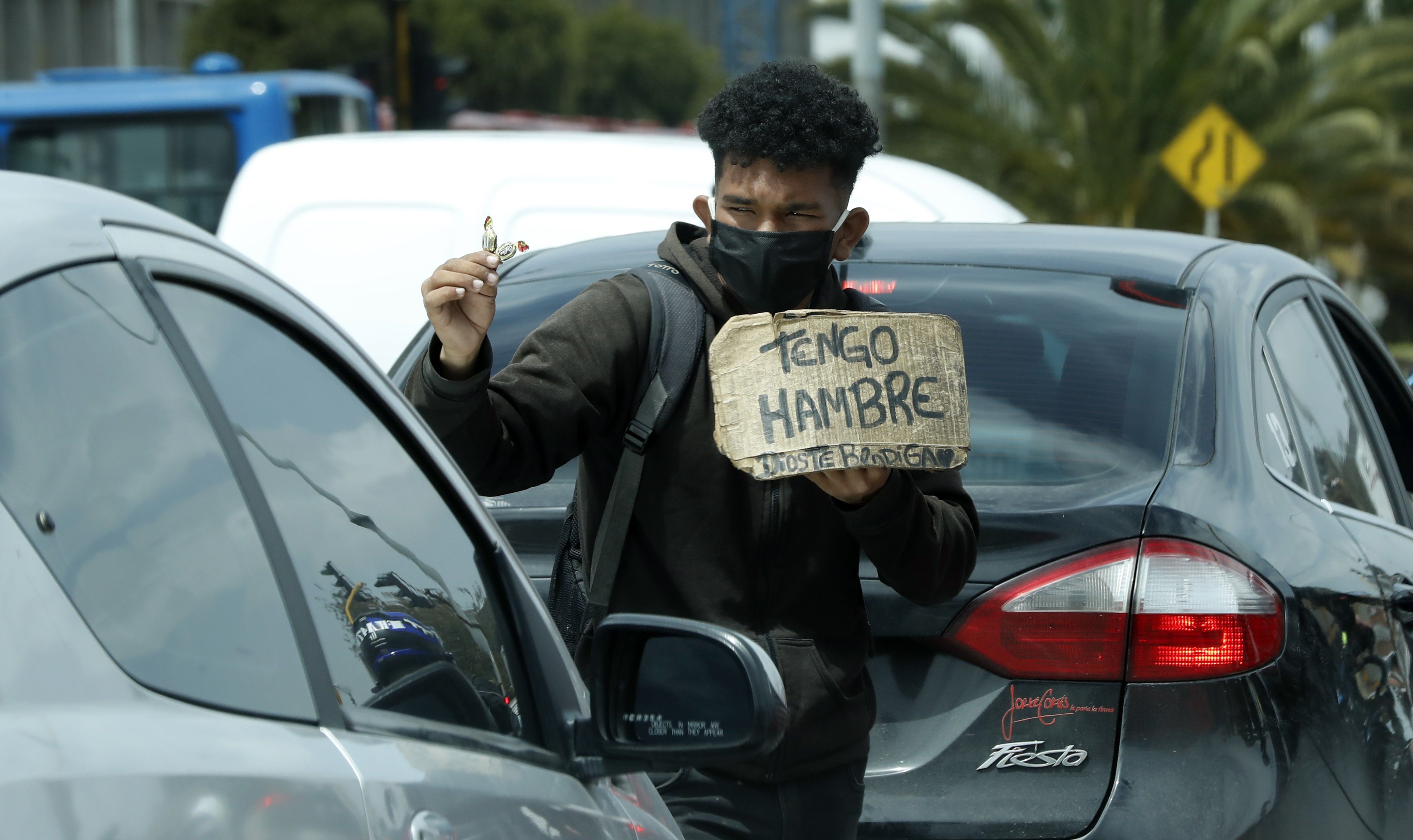 Un hombre vende dulces y pide ayuda en un semáforo, en Bogotá (Colombia). EFE/ Mauricio Duenas Castañeda/Archivo 