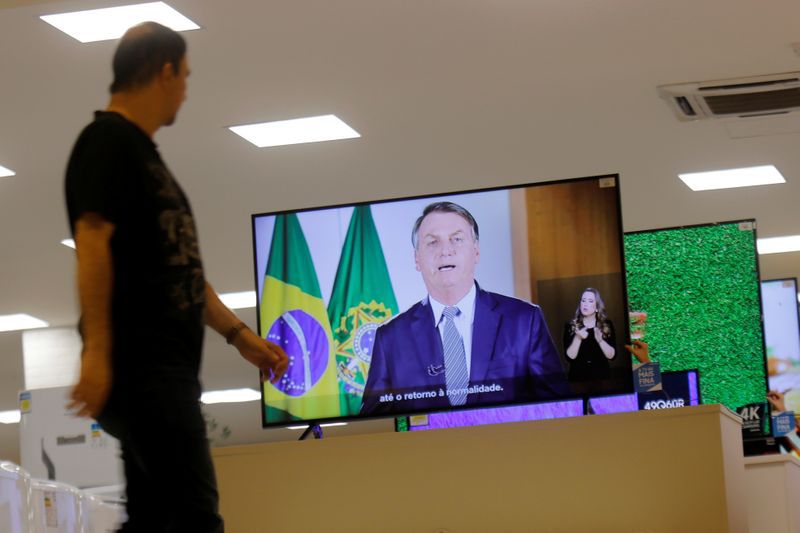FOTO DE ARCHIVO. Un hombre pasa junto a un televisor que transmite una declaración del presidente de Brasil, Jair Bolsonaro, sobre el coronavirus, en una tienda en Brasilia, Brasil. 6 de marzo de 2020. REUTERS/Adriano Machado