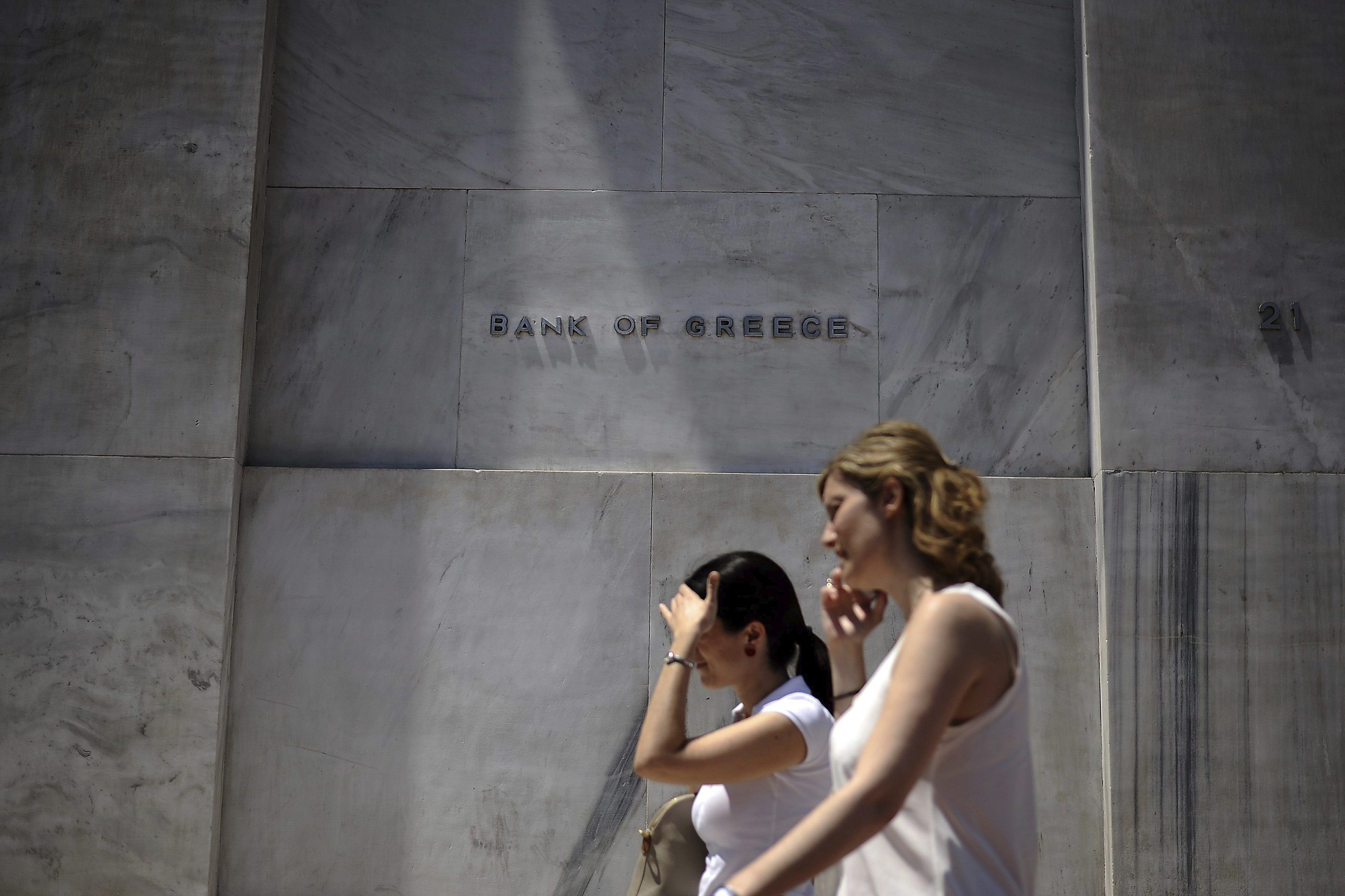 Dos mujeres pasan delante de la sede del Banco Central de Grecia en Atenas. EFE/Fotis Plegas G./Archivo 