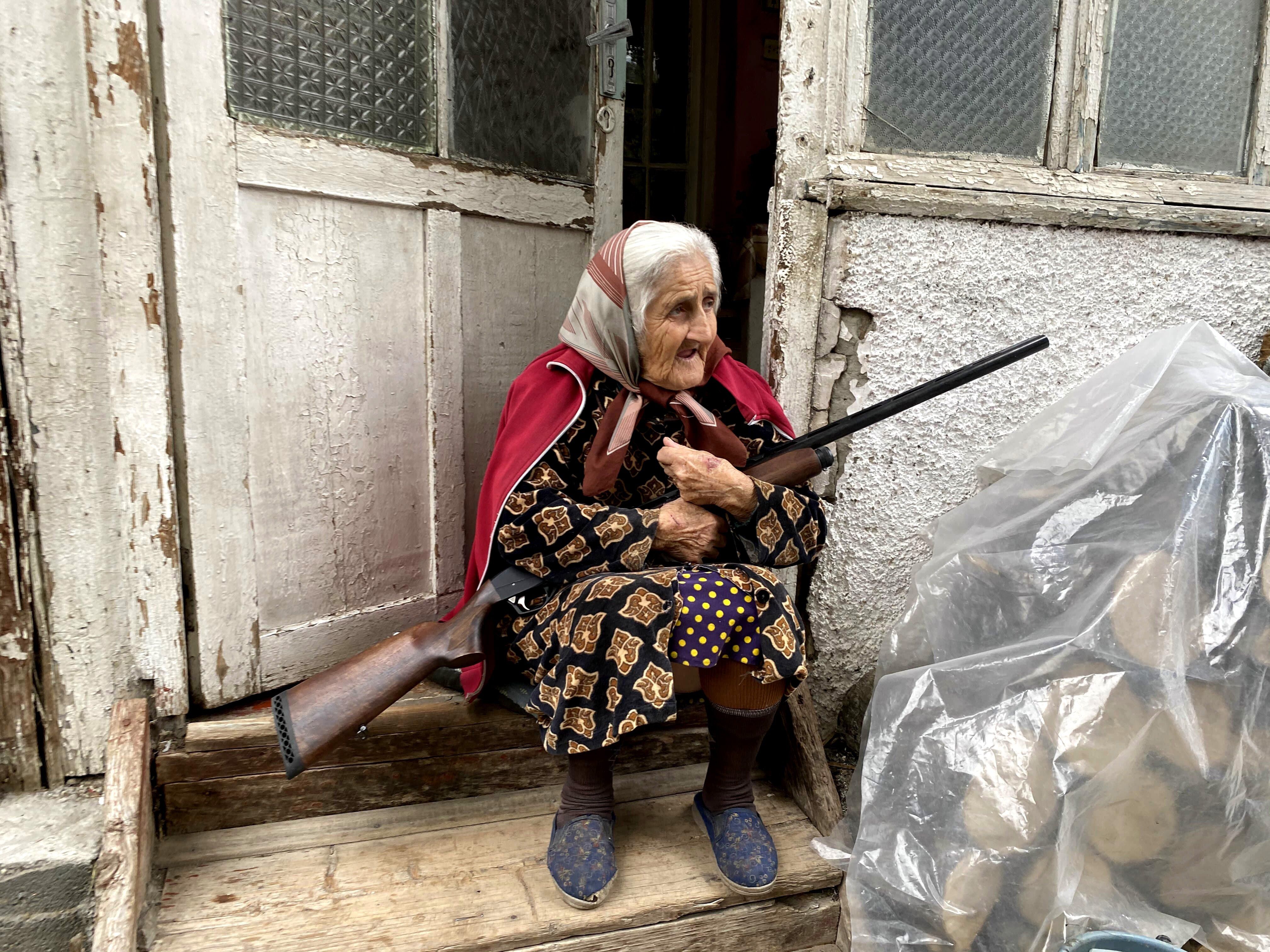 Una anciana con su escopeta en la puerta de su casa en Stepanakert, la capital del enclave separatista de Nagorno Karabaj disputada por Azerbaiyán y Armenia, que ha vuelto a ser atacada con cohetes. EFE/Pablo González 