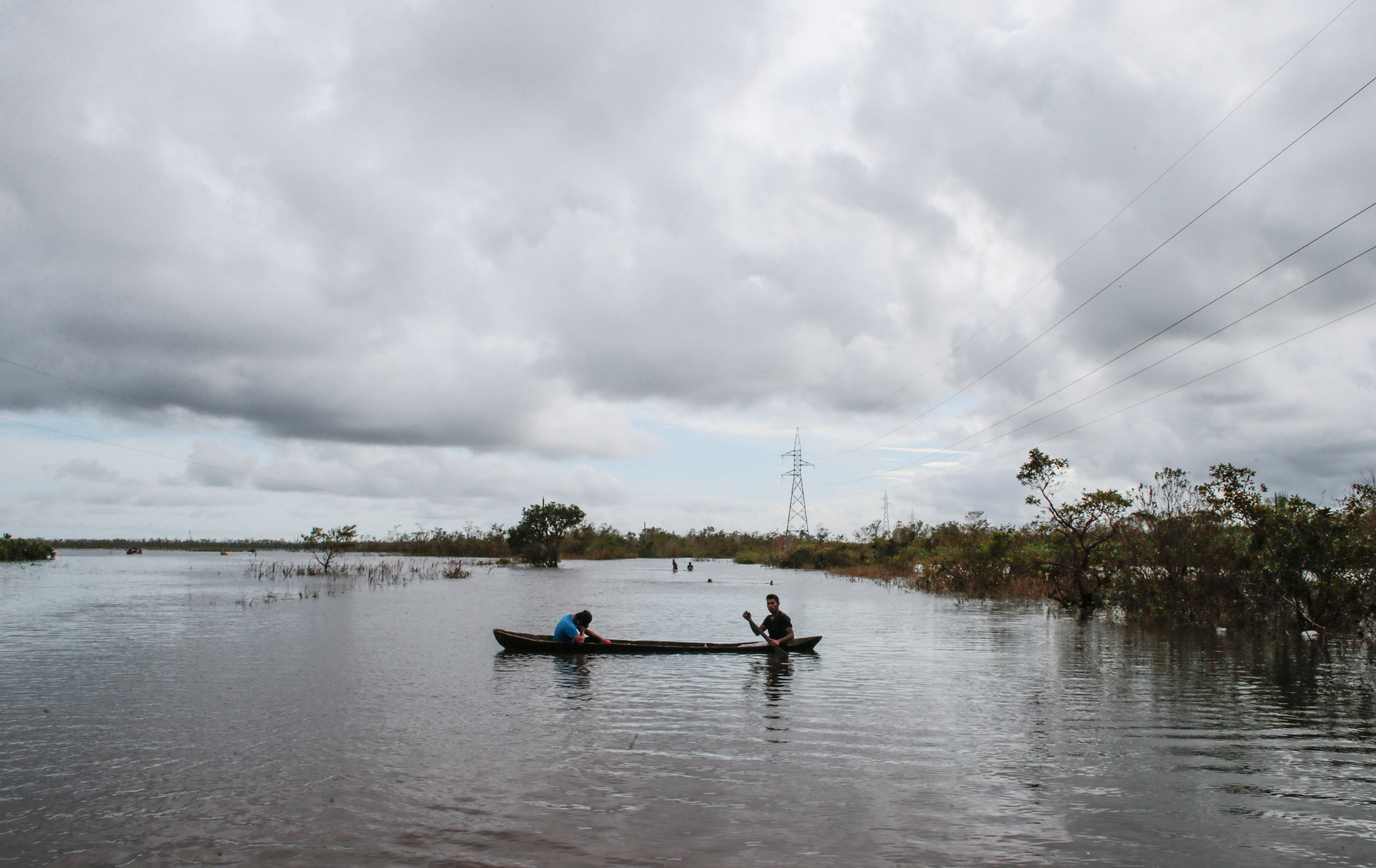 Personas navegan en botes luego de las inundaciones causadas por el huracán Iota 
