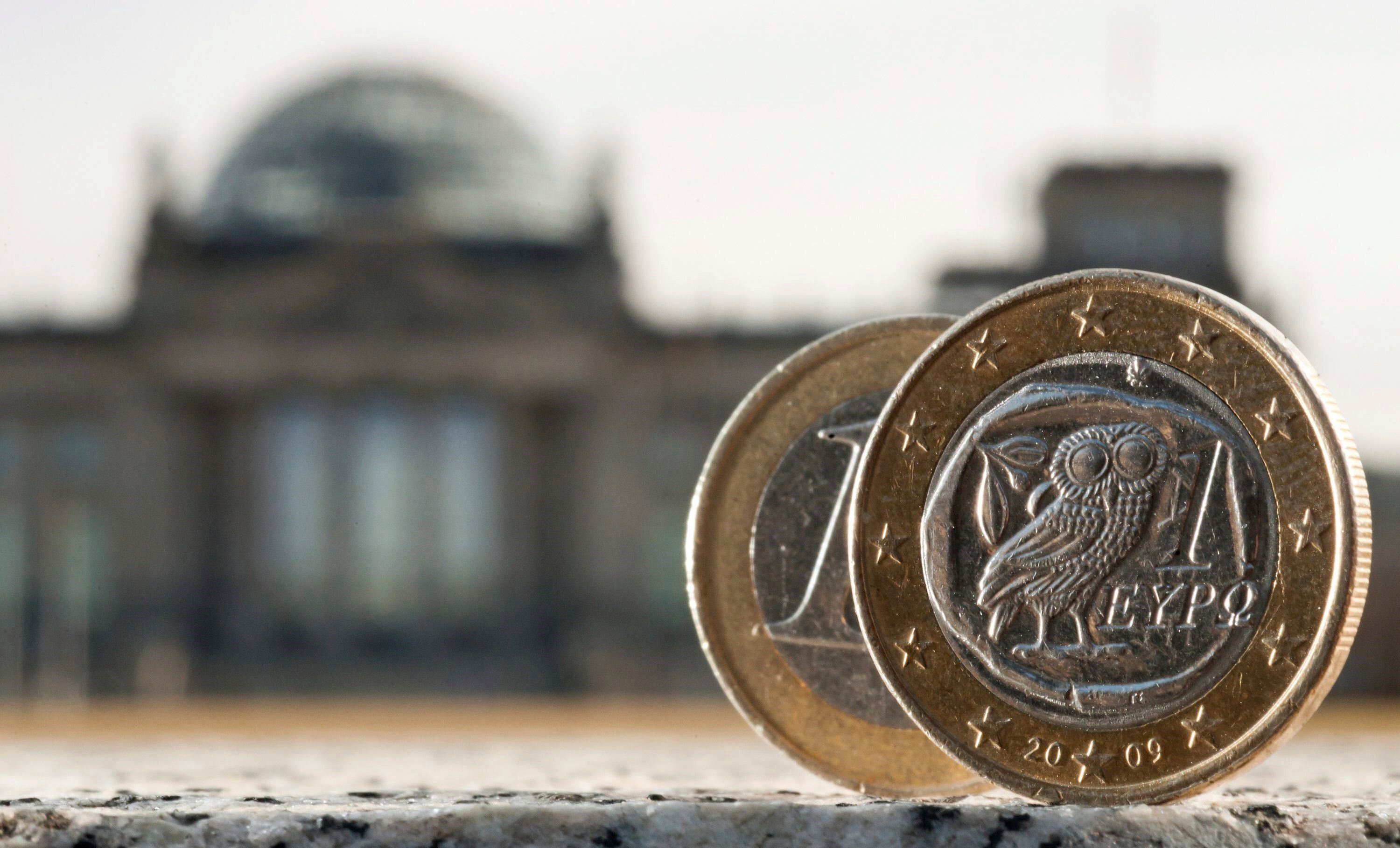 Dos monedas de euro, una de ellas acuñada en Grecia, fotografiadas delante del Bundestag. EFE/Tim Brakemeier/Archivo 