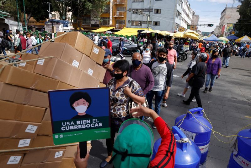 Se ve gente en la calle mientras continúa el brote de la enfermedad por coronavirus (COVID-19) en Ciudad de México, México 4 de diciembre de 2020. El letrero dice: "Use la máscara protectora correctamente". REUTERS / Carlos Jasso