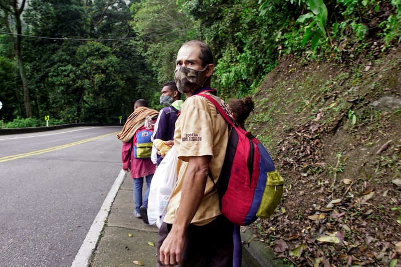 Migrantes venezolanos con máscaras faciales debido al brote de (COVID-19) caminan de regreso por las carreteras colombianas después de que los sectores económicos fueron reactivados, cerca a la ciudad de Bucaramanga, Colombia, 30 de octubre, 2020. REUTERS/Natalia Ortiz NO REVENTAS. NO ARCHIVO