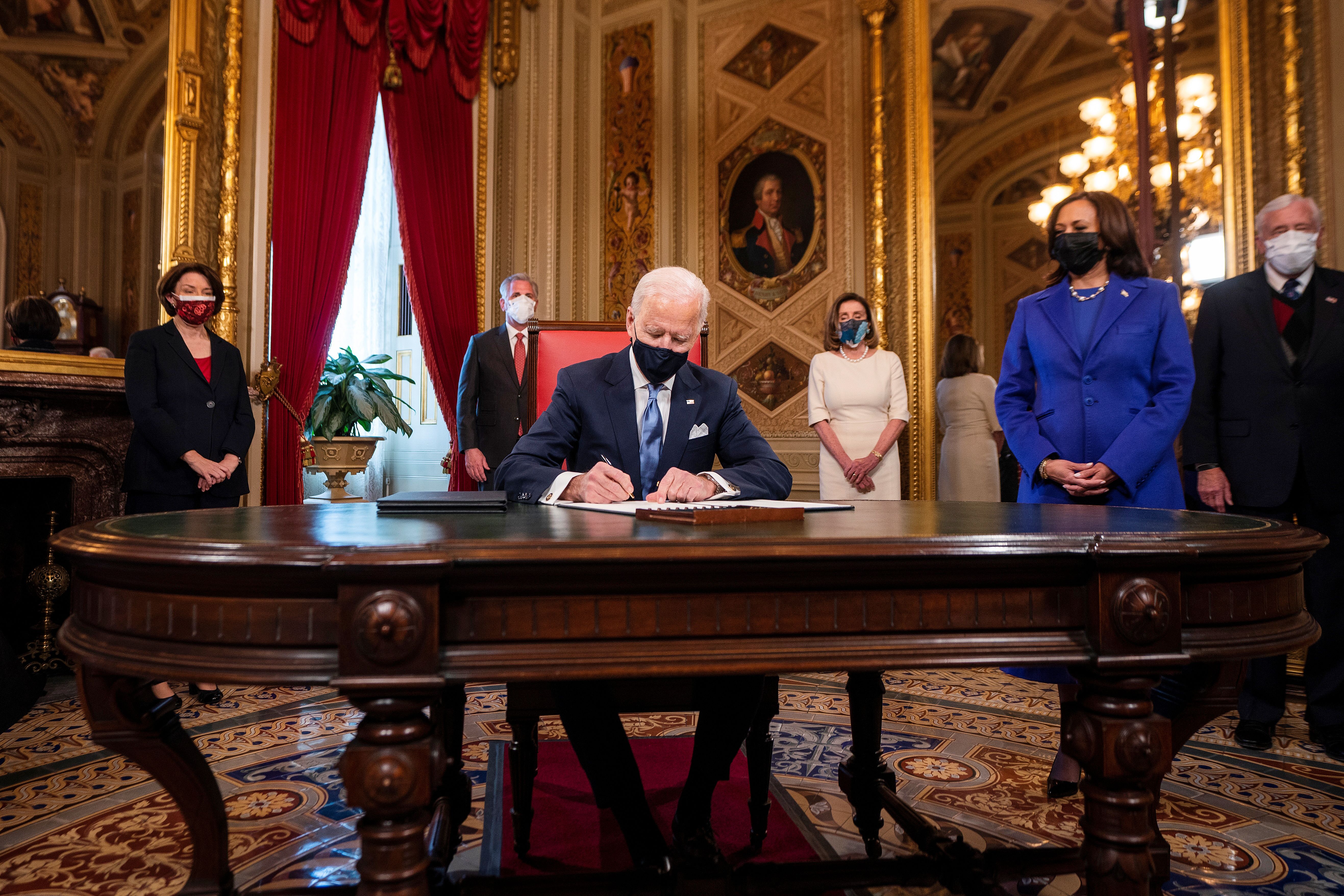 El presidente estadounidense Joe Biden firma sus primertos documentos oficiales (Jim Lo Scalzo/Pool via REUTERS)