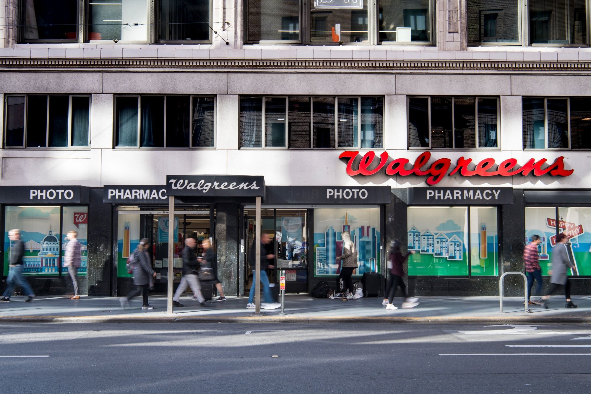 Pedestrians pass in front of a Walgreens Boots Alliance Inc. store in San Francisco, California.