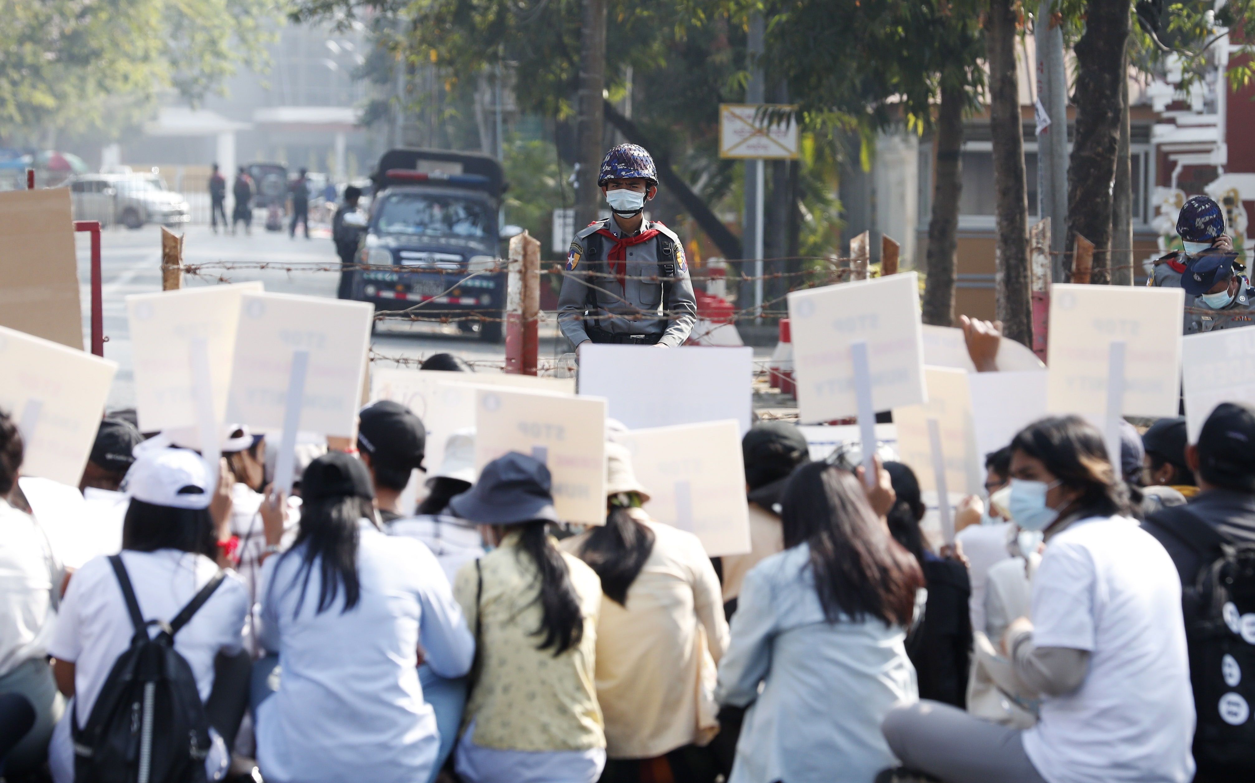 Manifestantes sostienen pancartas detrás de una barricada policial durante una protesta contra el supuesto apoyo del gobierno indonesio a nuevas elecciones por parte de la junta militar, frente a la Embajada de Indonesia, en Yangon, Myanmar.EFE/EPA/NYEIN CHAN NAING 