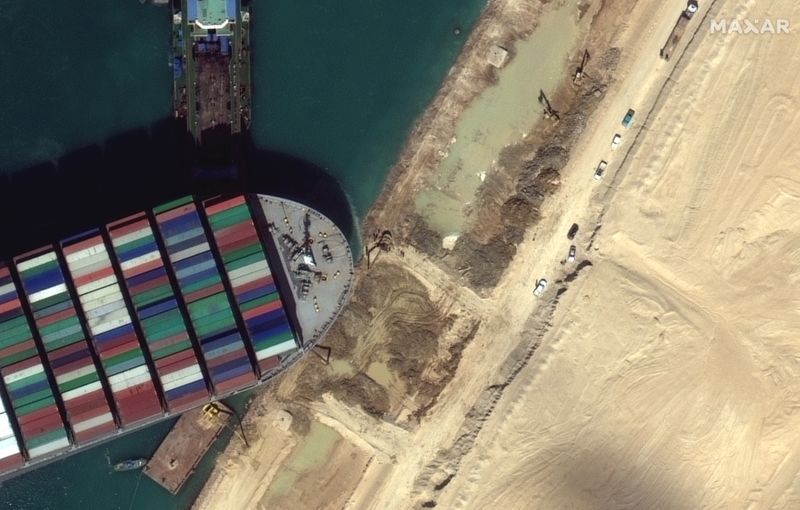 Una vista del equipo de movimiento de tierra que excava arena cerca de la proa del barco de contenedores Ever Given, en el Canal de Suez en esta imagen satelital de Maxar Technologies tomada el 27 de marzo de 2021 (REUTERS)