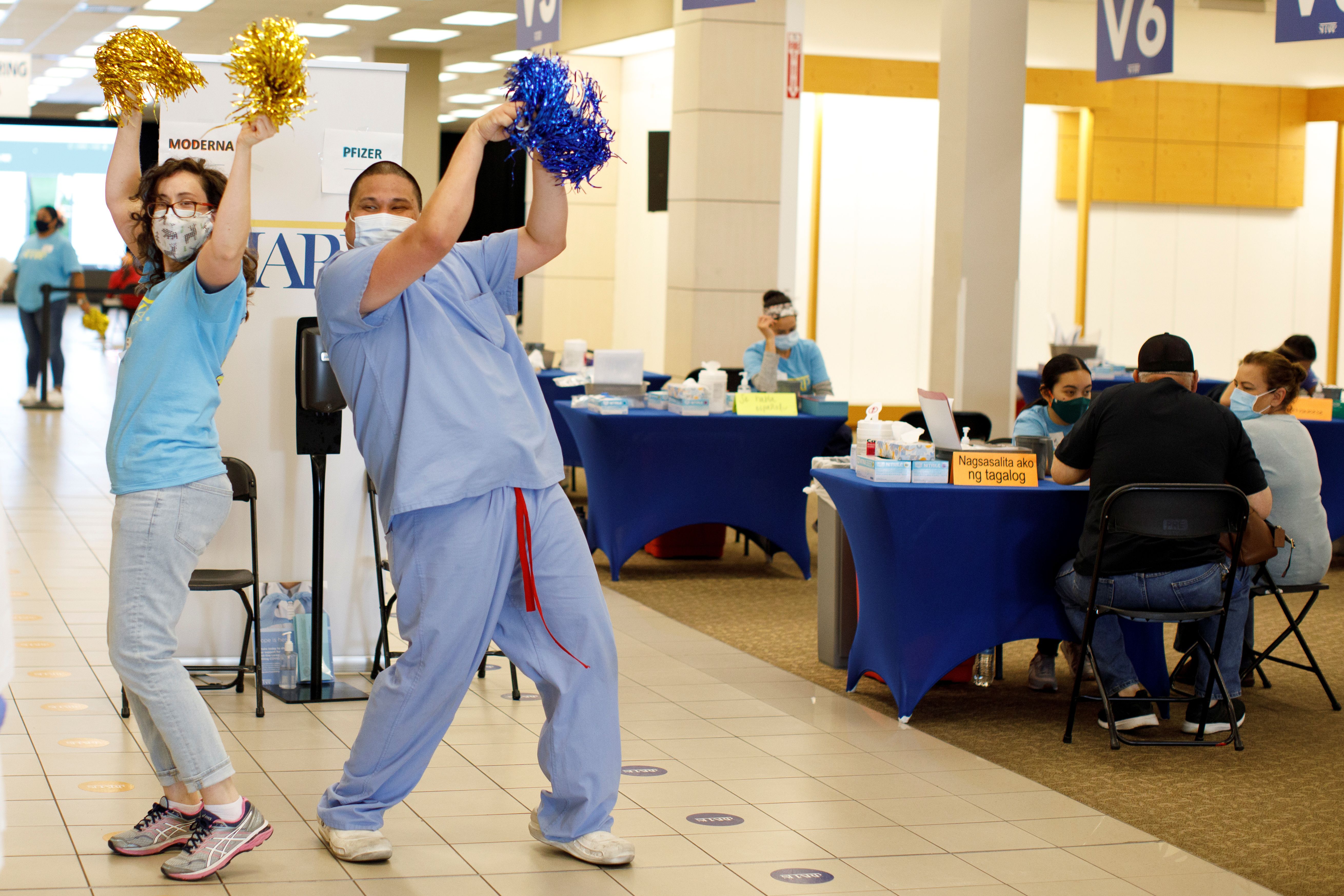 Dos enfermeras voluntarias bailan para darle la bienvenida a los jóvenes al vacunatorio de Chula Vista, California (REUTERS/Mike Blake)