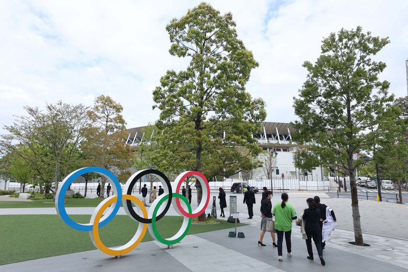 FOTO DE ARCHIVO: Gente pasa junto a la escultura de los anillos olímpicos cerca del Estadio Nacional de Japón en preparación para los Juegos Olímpicos de Tokio 2020 que comenzarán en julio de 2021. Crédito obligatorio: Yukihito Taguchi-USA TODAY Sports