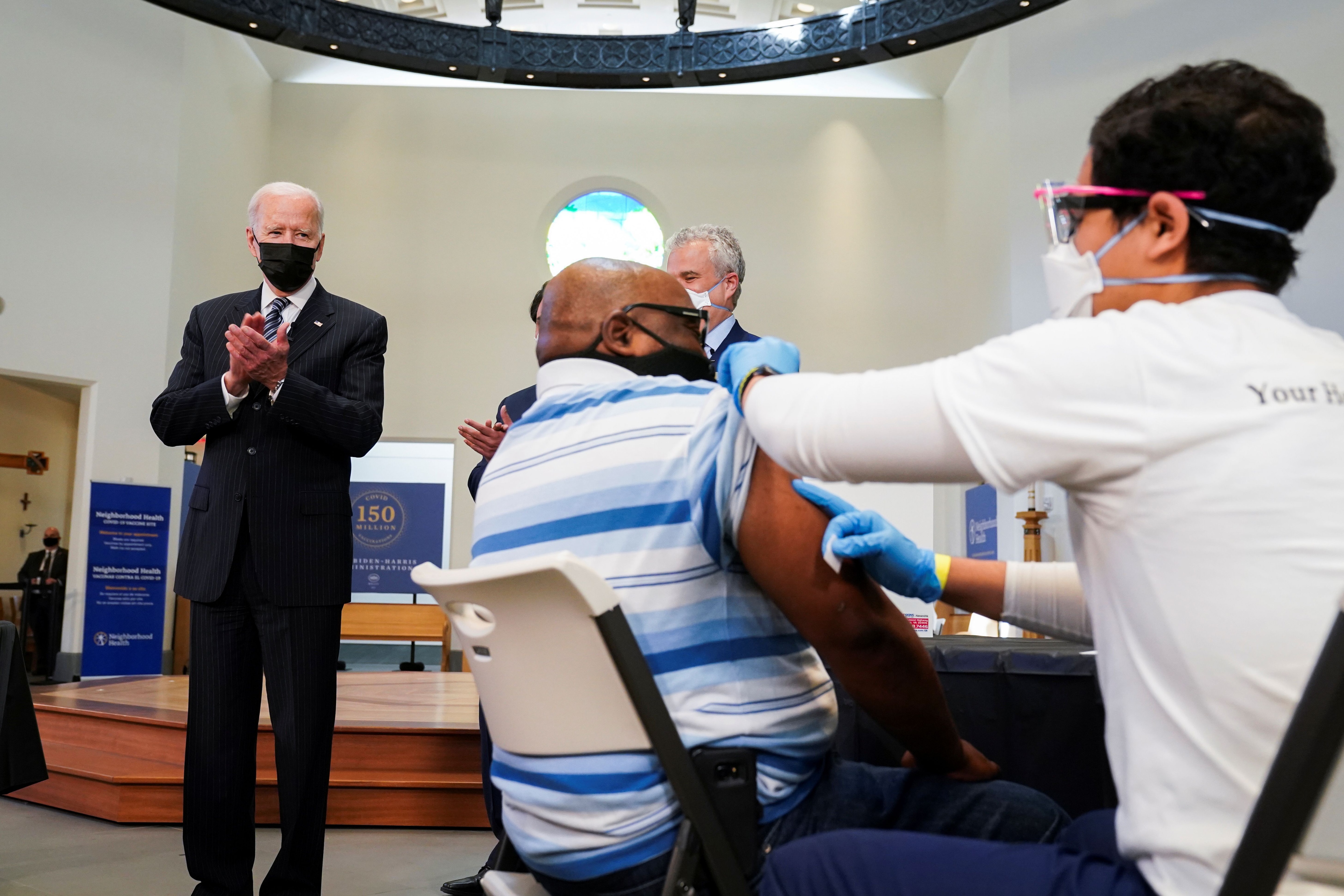 Joe Biden aplaude a un hombre mientras recibe una vacuna en el centro de vacunación del Seminario Teológico de Virginia en Alexandria, Virginia (Foto: REUTERS/Kevin Lamarque)