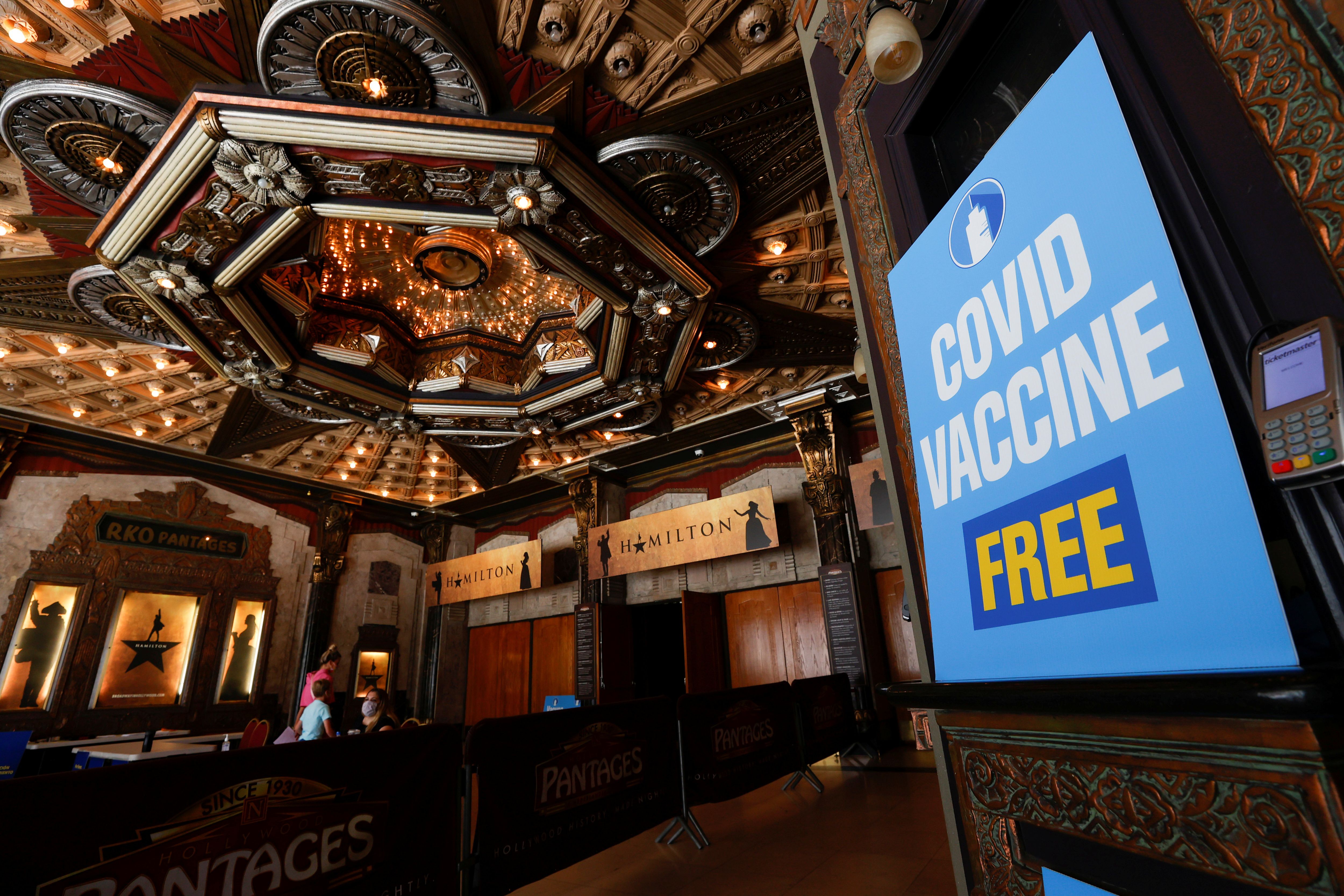 People walk in to receive a coronavirus disease (COVID-19) vaccine with a chance to win a pair of tickets to see "Hamilton" at a pop-up vaccination clinic at Pantages theatre in Los Angeles, California, U.S., June 12, 2021. REUTERS/Mario Anzuoni
