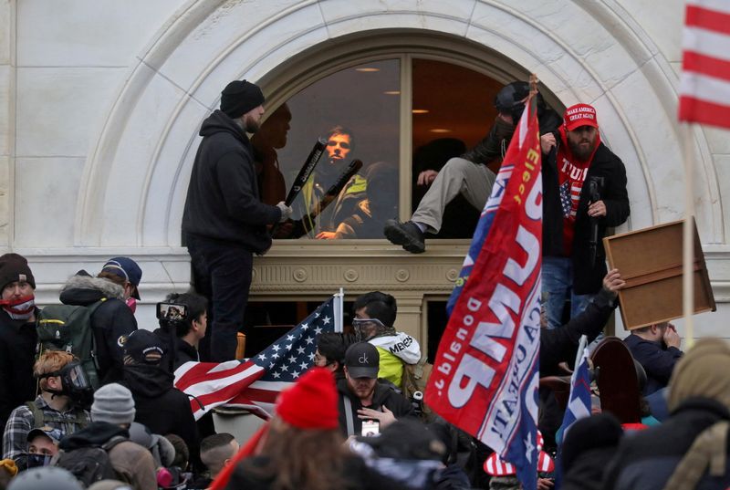 Una turba de simpatizantes de Donald Trump trepan por una ventana que rompieron mientras irrumpen en el edificio del Capitolio de Estados Unidos (Foto: REUTERS)