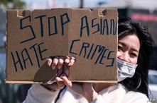A demonstrator wearing a face mask and holding a sign takes part in a rally to raise awareness of anti-Asian violence, near…