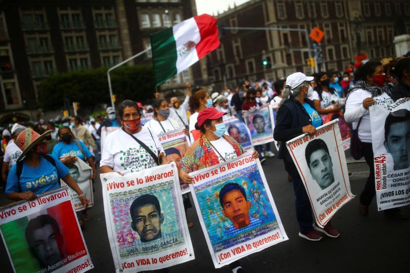 Familiares de los 43 estudiantes desaparecidos de la Escuela Normal Rural Raúl Isidro Burgos, de Ayotzinapa, sostienen pancartas mientras marchan en Ciudad de México para conmemorar el sexto aniversario de su desaparición. 26 de septiembre de 2020. REUTERS/Edgard Garrido