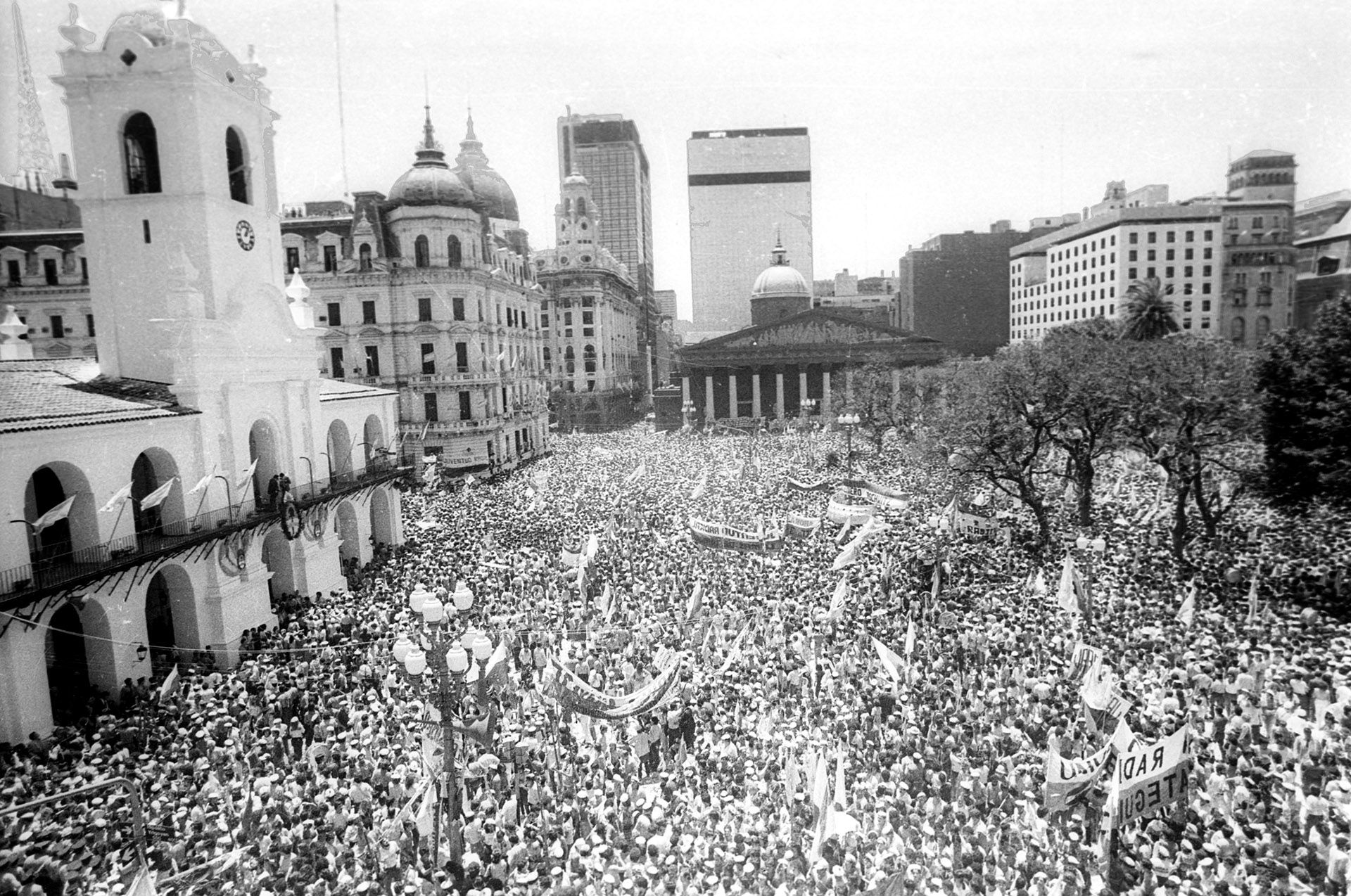 La gente en la Plaza de Mayo, de cara al Cabildo, desde donde Alfosín saludó a la multitud con la banda presidencial 