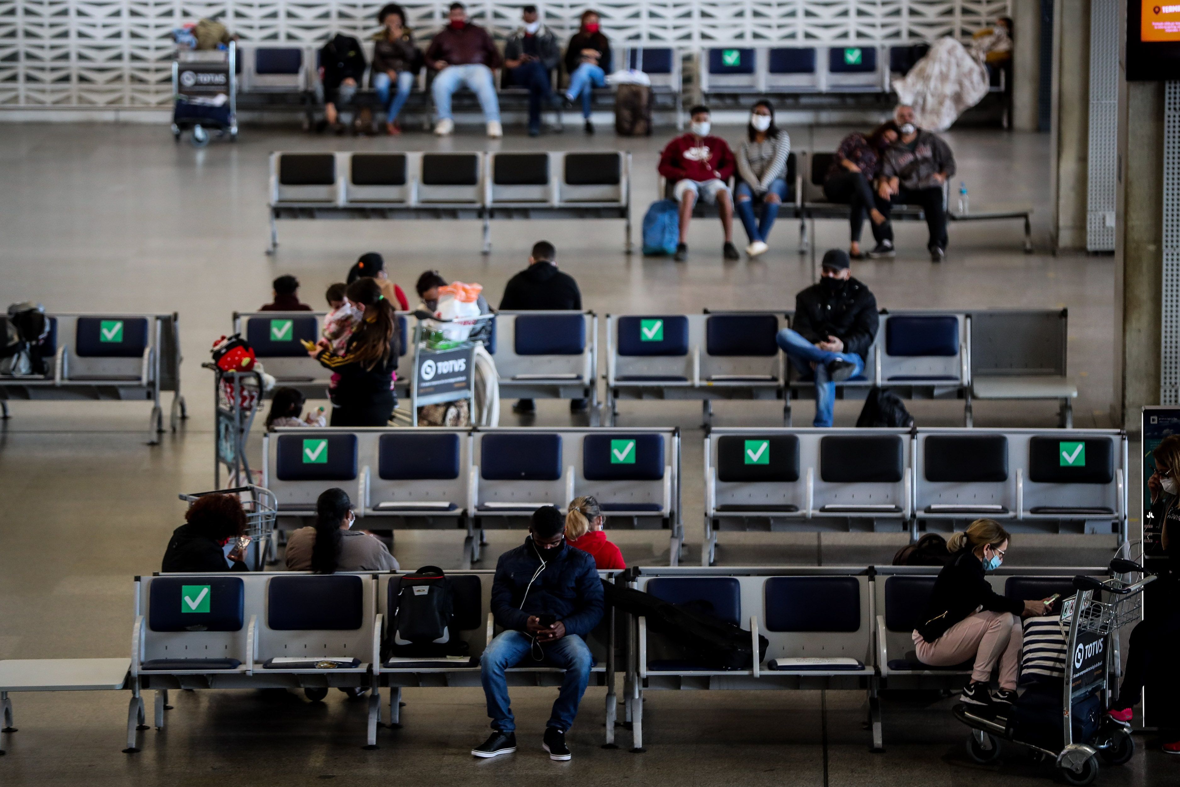 Personas esperan en la zona de embarque del aeropuerto internacional de Guarulhos en Sao Paulo (Brasil) (Foto: EFE/Fernando Bizerra) 