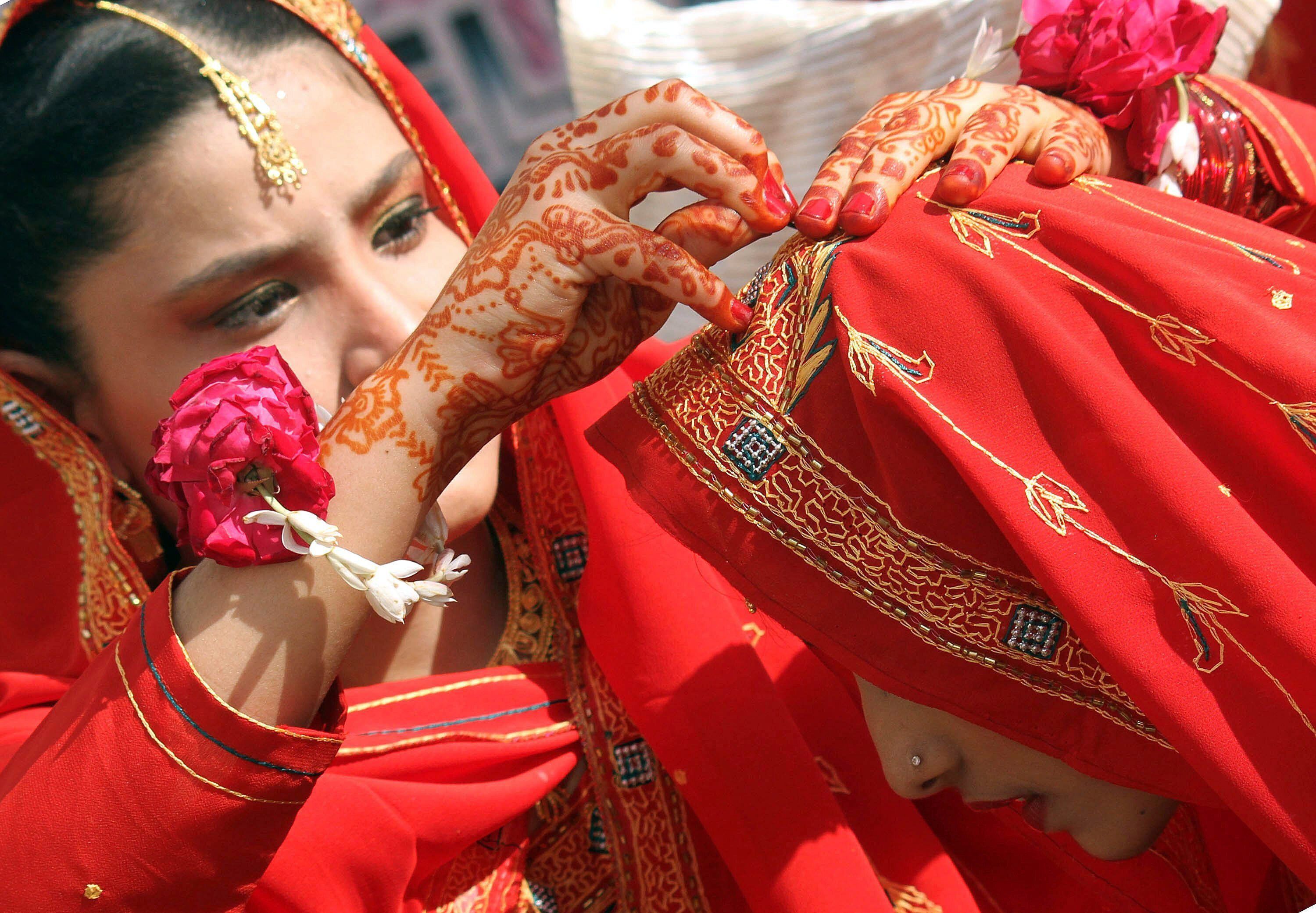 Dos novias se ayudan a colocar el pañuelo durante su ceremonia matrimonial múltiple en Karachi (Pakistán) en una imagen de archivo. EFE/Rehan 