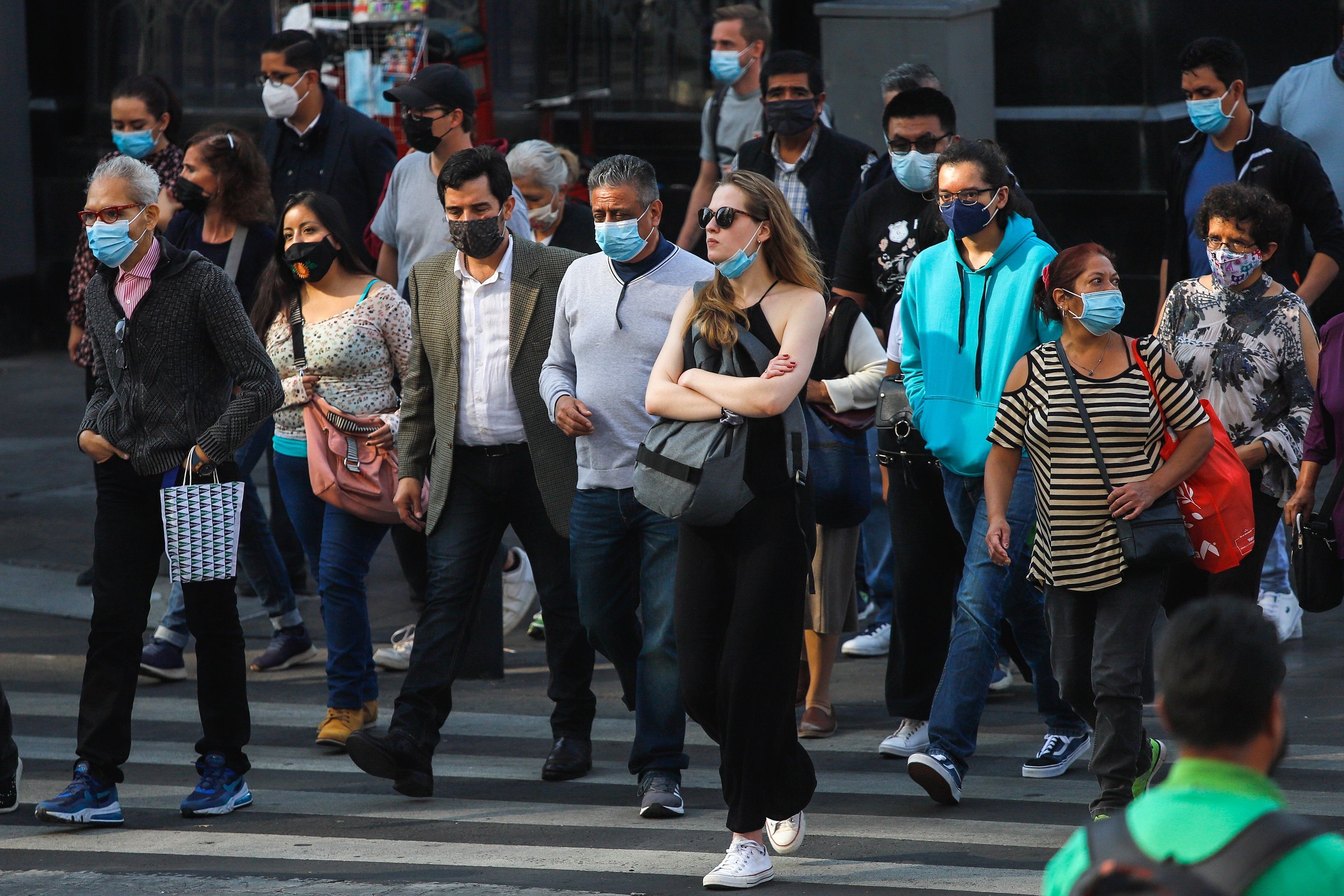 Personas con cubrebocas caminan por las calles del Centro Histórico hoy, en la Ciudad de México (México). EFE/Madla Hartz 