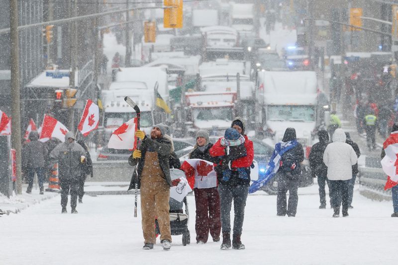 Manifestantes caminan por el centro de la ciudad mientras los camioneros y sus partidarios siguen protestando por el mandato de vacunación contra la enfermedad del coronavirus (COVID-19), en Ottawa, Ontario, Canadá. 12 de febrero de 2022. REUTERS/Blair Gable