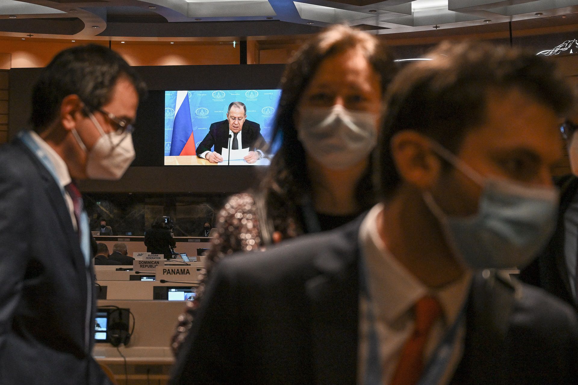 Ambassadors and diplomats walkout while Russia's foreign minister Sergei Lavrov (C on screen) addresses with a pre-recorded video message the Conference on Disarmament in Geneva on March 1, 2022. - The diplomats got up and left the room when Sergei Lavrov's pre-recorded video message began to play, in protest against Moscow's invasion of Ukraine. (Photo by Fabrice COFFRINI / POOL / AFP)