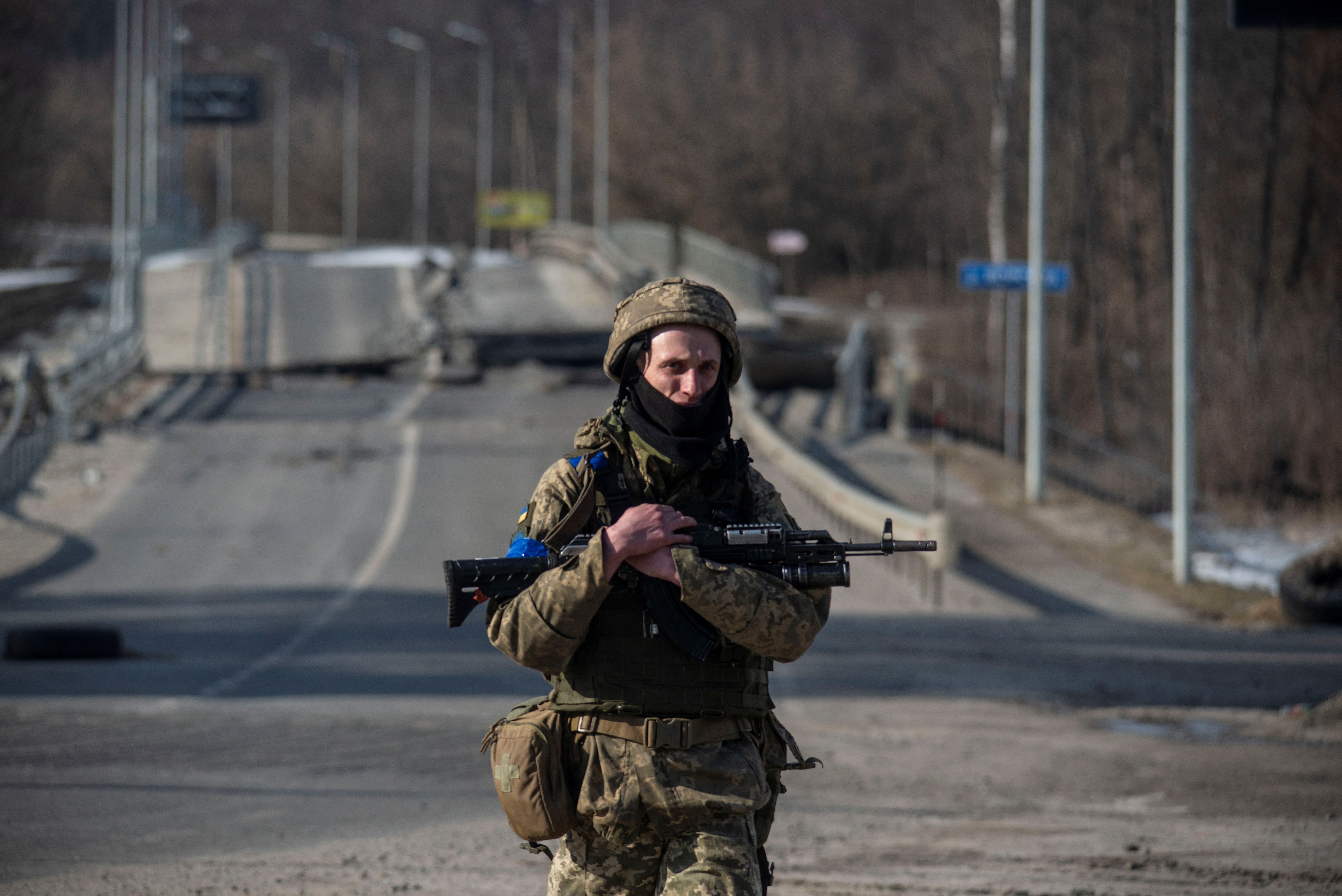 Un miembro del ejercito ucraniano camina junto a un puente destruido entre las ciudades de Trostianets y Okhtyrka, el 19 de marzo de 2022. (Iryna Rybakova/Servicio de prensa de Ucrania/REUTERS)