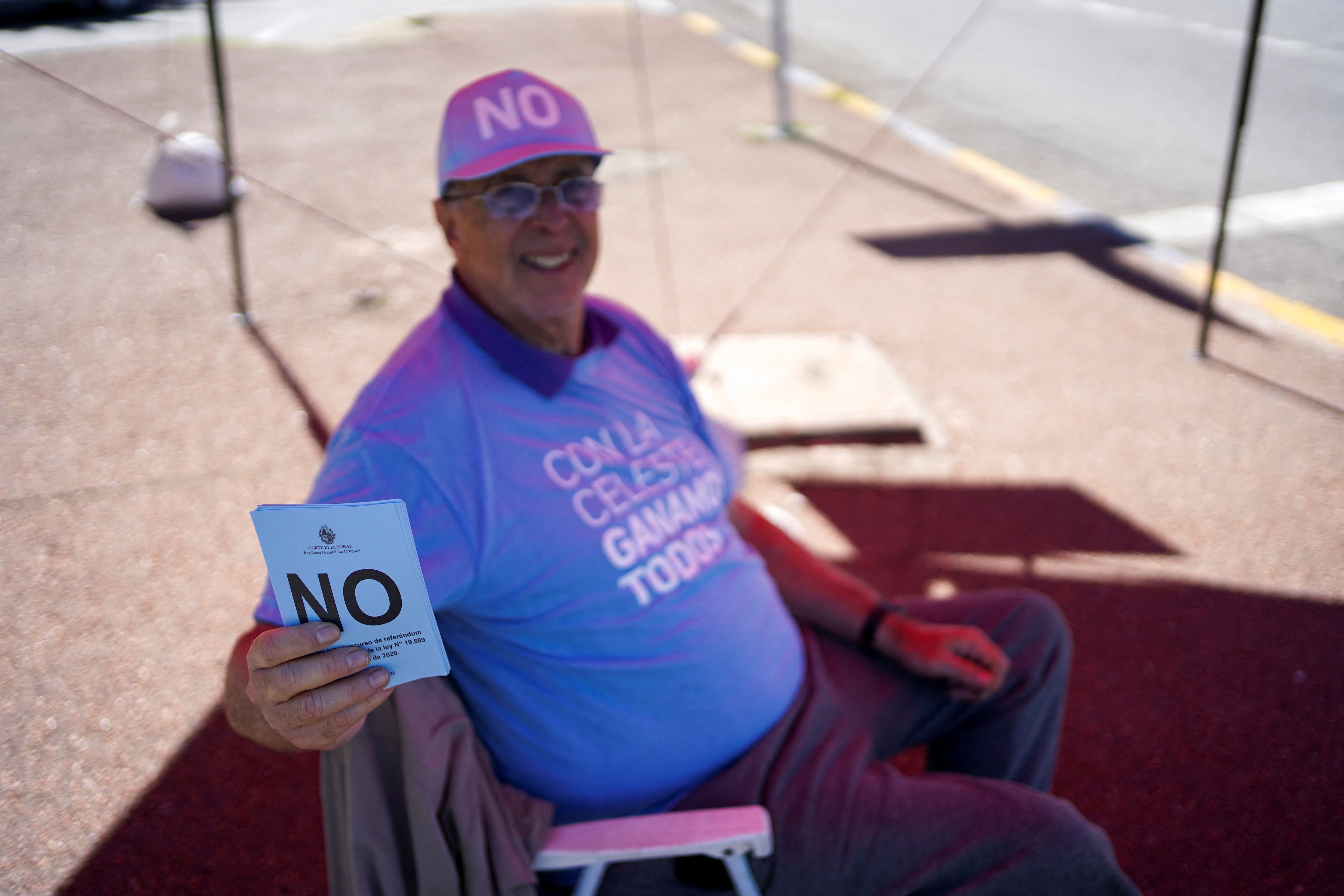 Un voluntario de la mesa electoral sostiene las papeletas azules del 'No' 