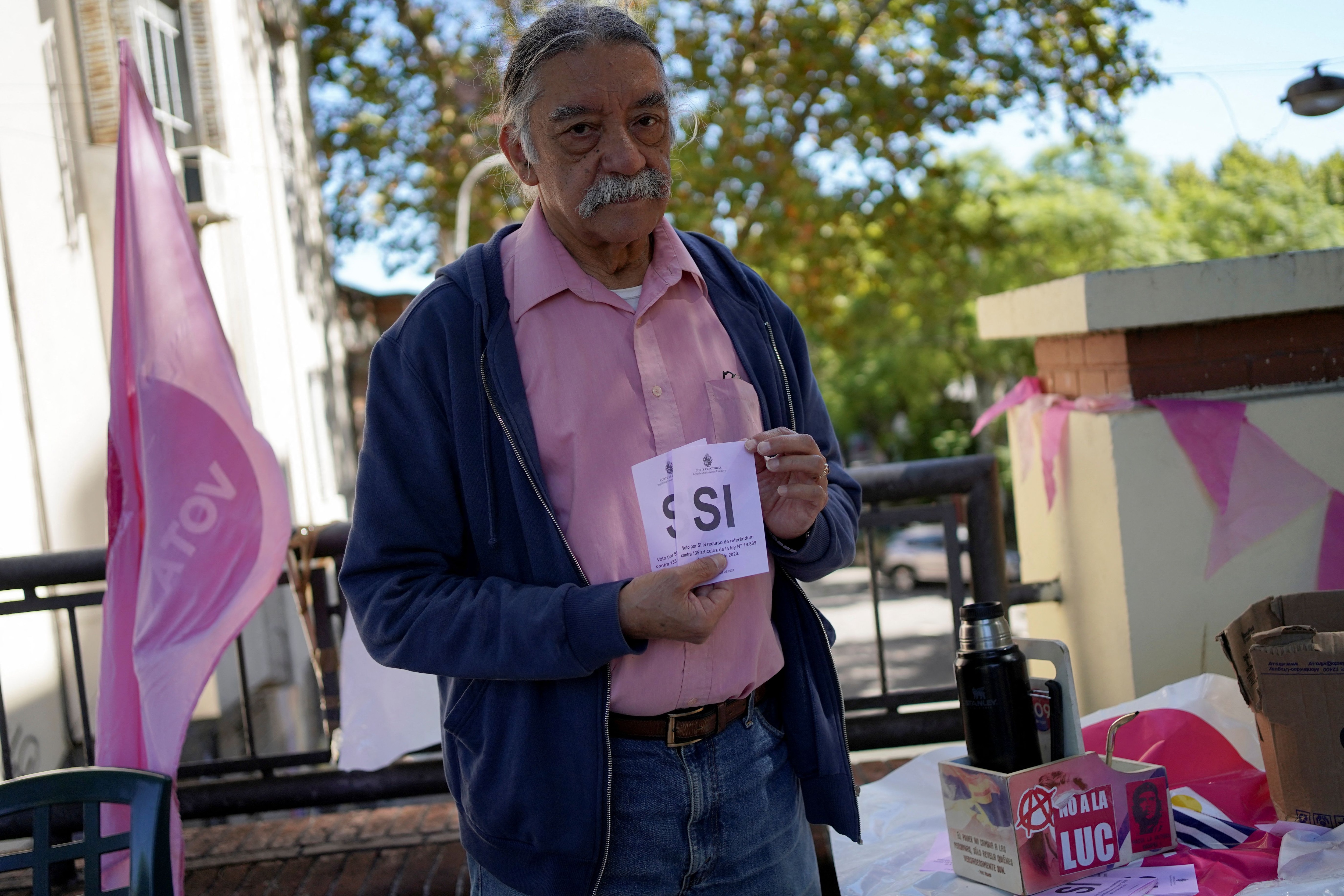 Un voluntari de la mesa electoral sostiene las papeletas rosas del 'Sí' para un referéndum sobre la eliminación o no de 135 artículos de la Ley de Consideración Urgente, fuera de un colegio electoral en Montevideo, Uruguay el 27 de marzo de 2022. REUTERS