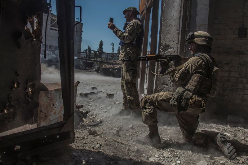 Miembros del servicio ucraniano observan mientras un tanque dispara hacia las tropas rusas en la zona industrial de la ciudad de Severodonetsk, mientras continúa el ataque de Rusia a Ucrania