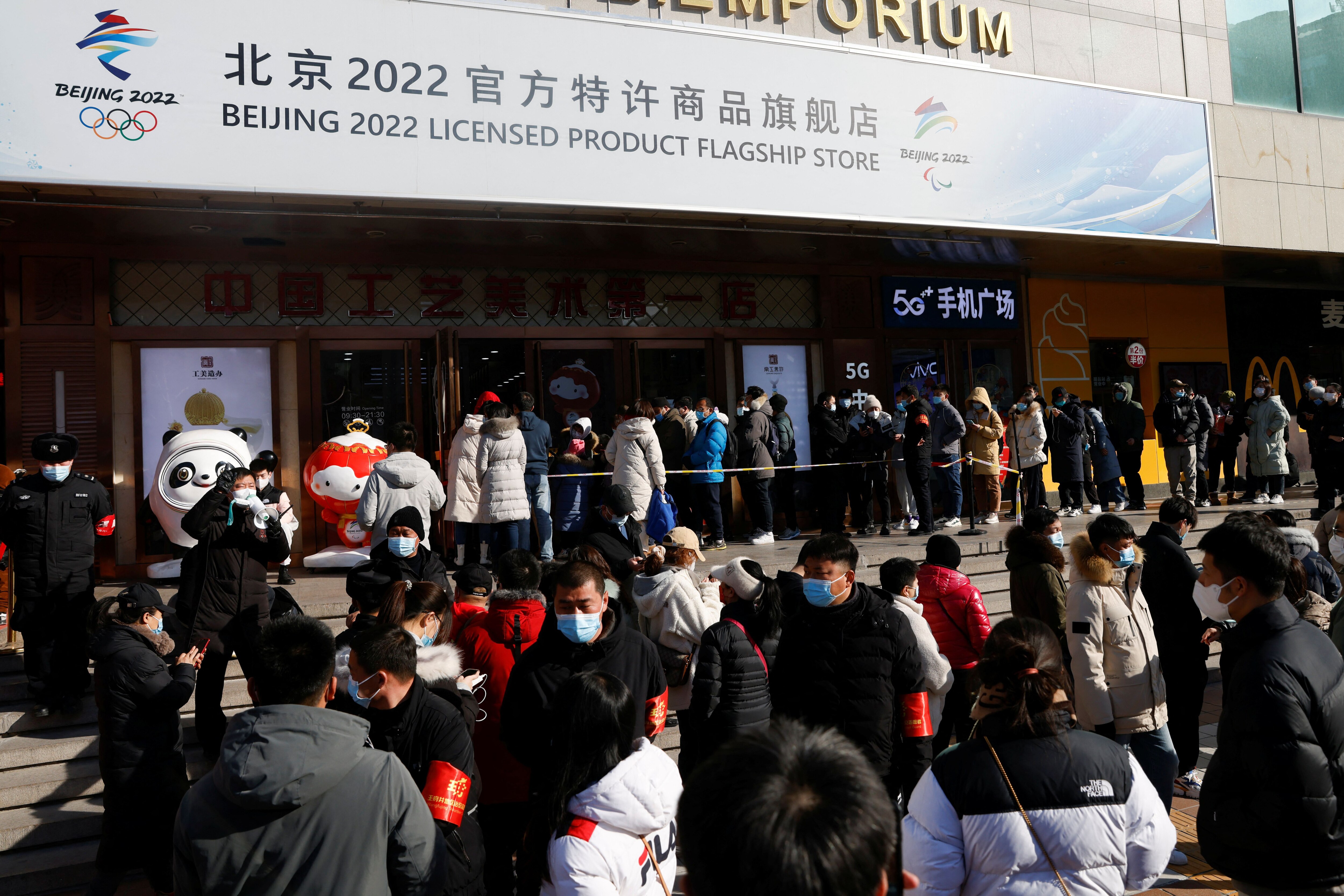 People wearing face masks, following the coronavirus disease (COVID-19) outbreak, queue to enter a flagship merchandise store for the Beijing 2022 Winter Olympics at Wangfujing street in Beijing, China February 5, 2022. REUTERS/Carlos Garcia Rawlins